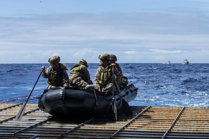 Marines with Kilo Company, Battalion Landing Team 3/4, 31st Marine Expeditionary Unit, prepare to offload in combat rubber raiding crafts from dock-landing ship USS Ashland during a Mark VI patrol boat resupply operation in the Philippine Sea, Feb. 25, 2021.