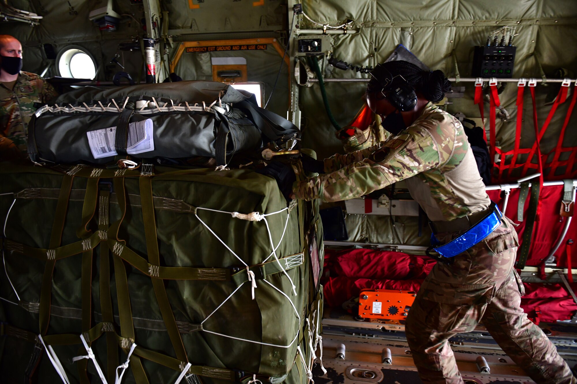 A person pushes a pallet onto a C-130J