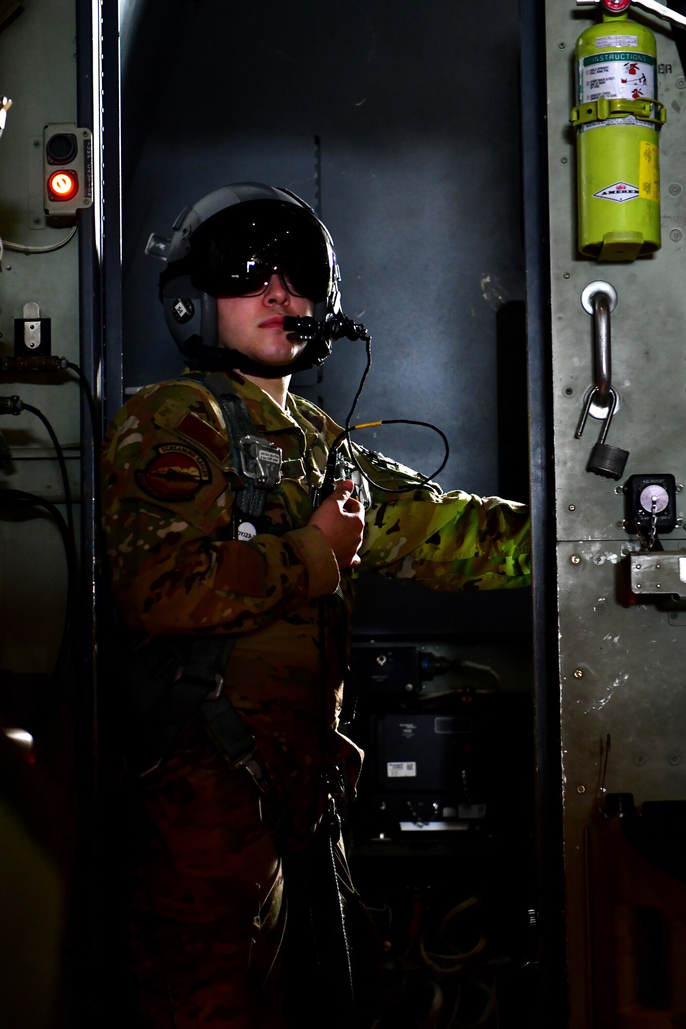 An Airman opens the rear hatch of an aircraft