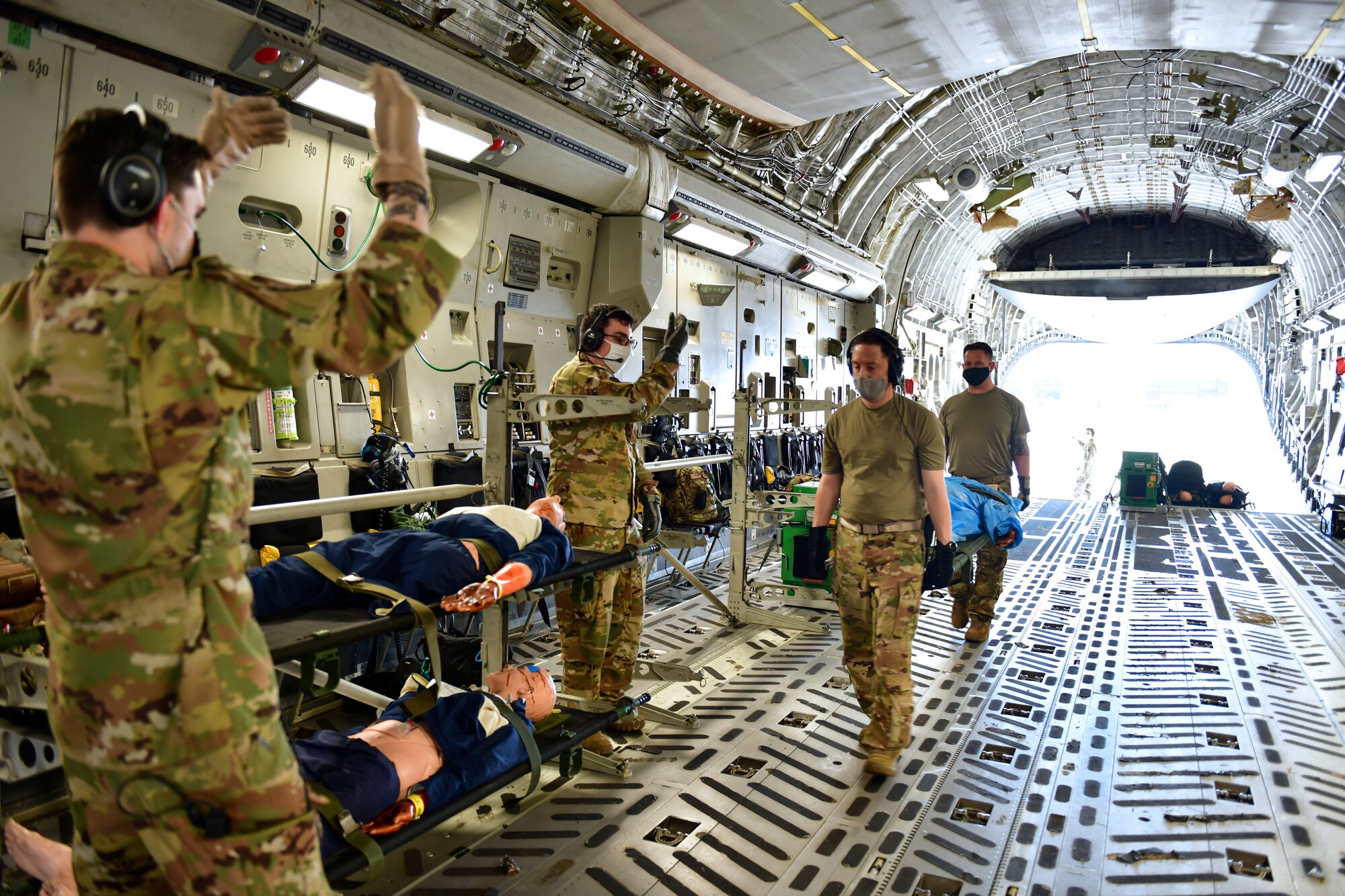 People transload patients onto an aircraft