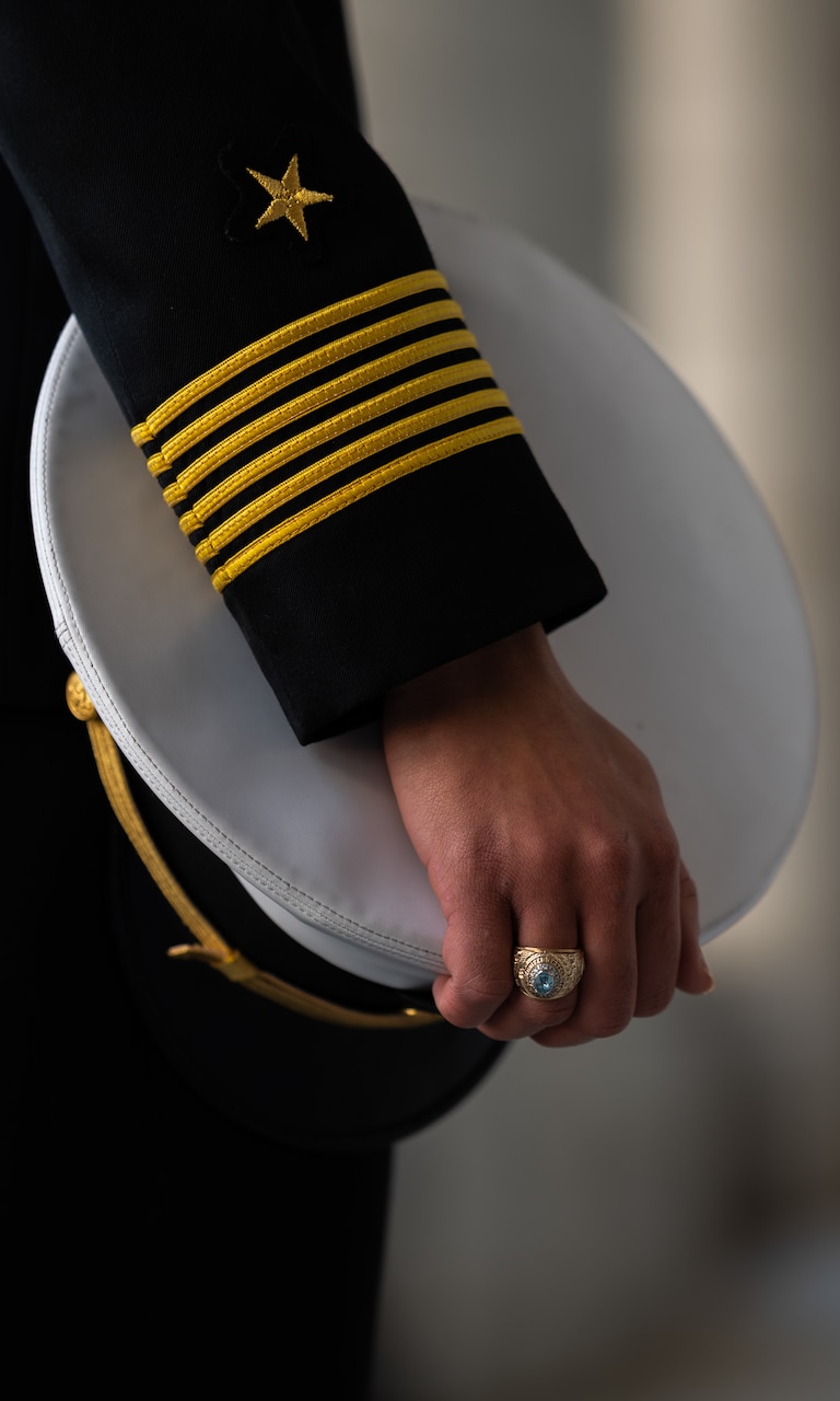 A sailor shows her class ring.