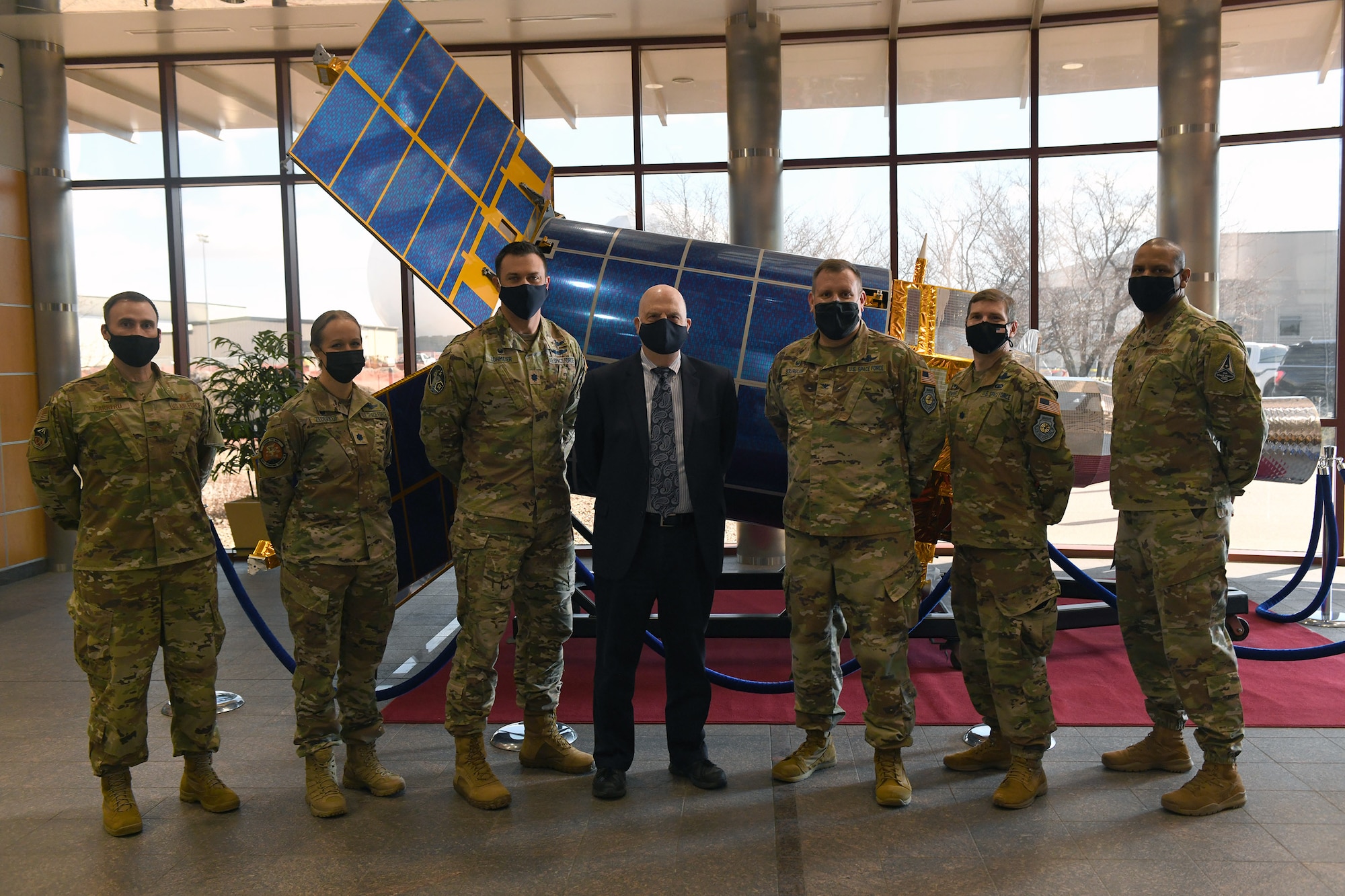The Honorable John P. Roth, Acting Secretary of the Air Force, and members of Space Delta 4 pose for a photo in front of a Defense Support Program spacecraft model in the Mission Control Station on Buckley Air Force Base, Colo., March 11, 2021. During his visit, Team Buckley demonstrated their alignment with the Department of the Air Force priorities. (U.S. Space Force photo by Airman 1st Class Haley N. Blevins)