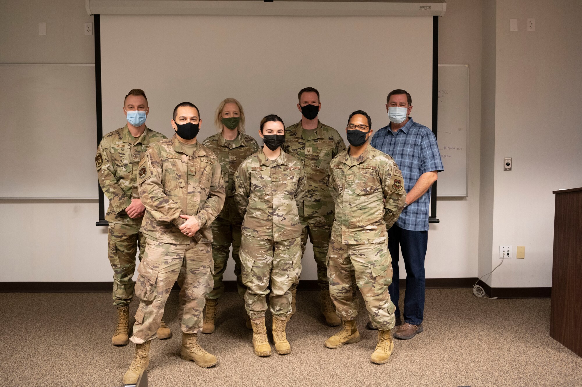 Airmen assigned to Travis Air Force Base, California, and Kirk Whitman, installation violence prevention integrator, pose for photo during Leadership Rounds at Travis AFB, California, March 12, 2021. Col. Corey Simmons, 60th Air Mobility Wing commander, presented seven individuals with letters of appreciation for their participation in showcasing Team Travis’ new suicide and prevention virtual reality training. (U.S. Air Force photo by Airman 1st Class Alexander Merchak)