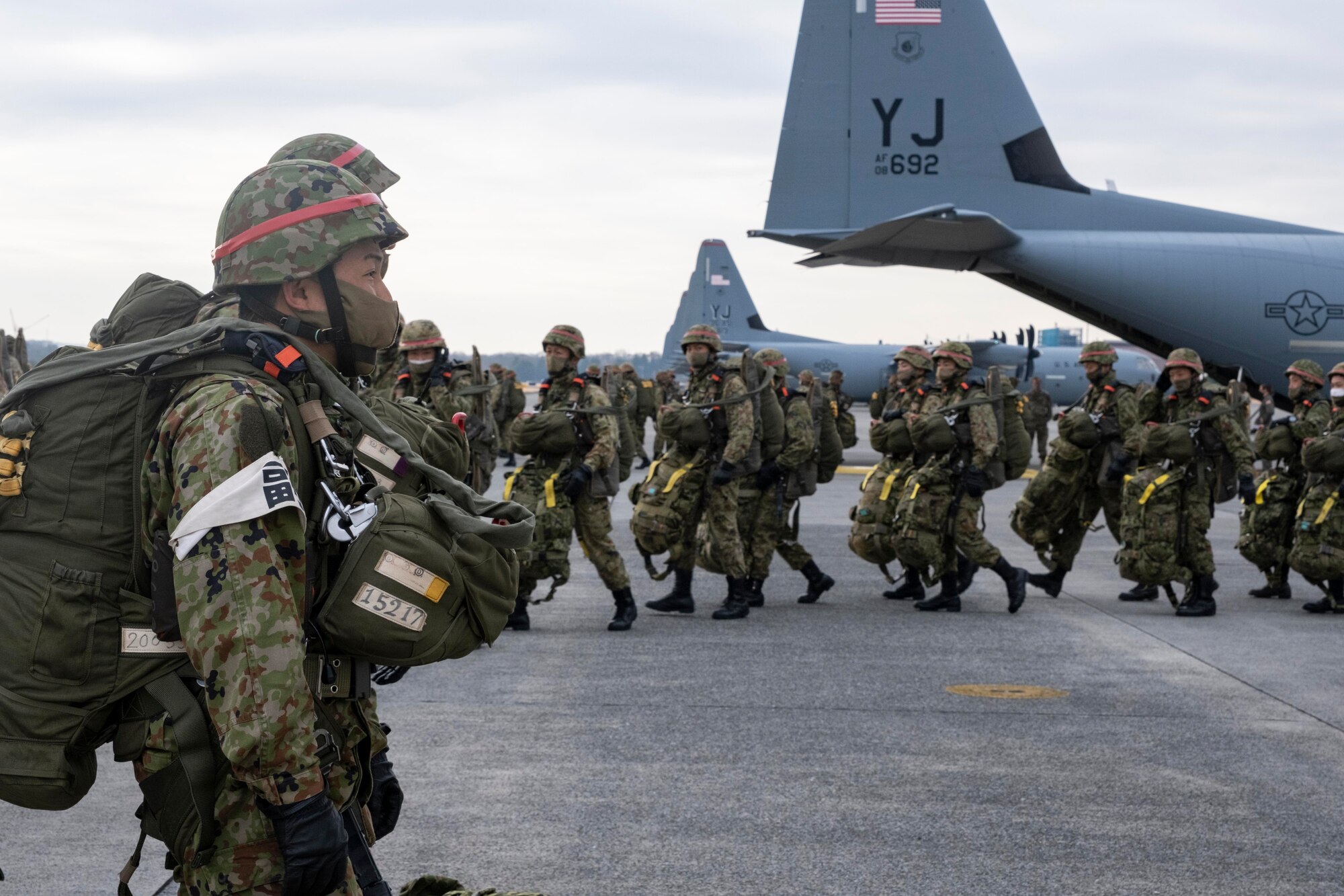 Japan Ground Self Defense Force paratroopers line up to load onto a C-130J Super Hercules, assigned to the 374th Airlift Wing, during exercise Airborne 21 at Yokota Air Base, Japan, March 9, 2021.