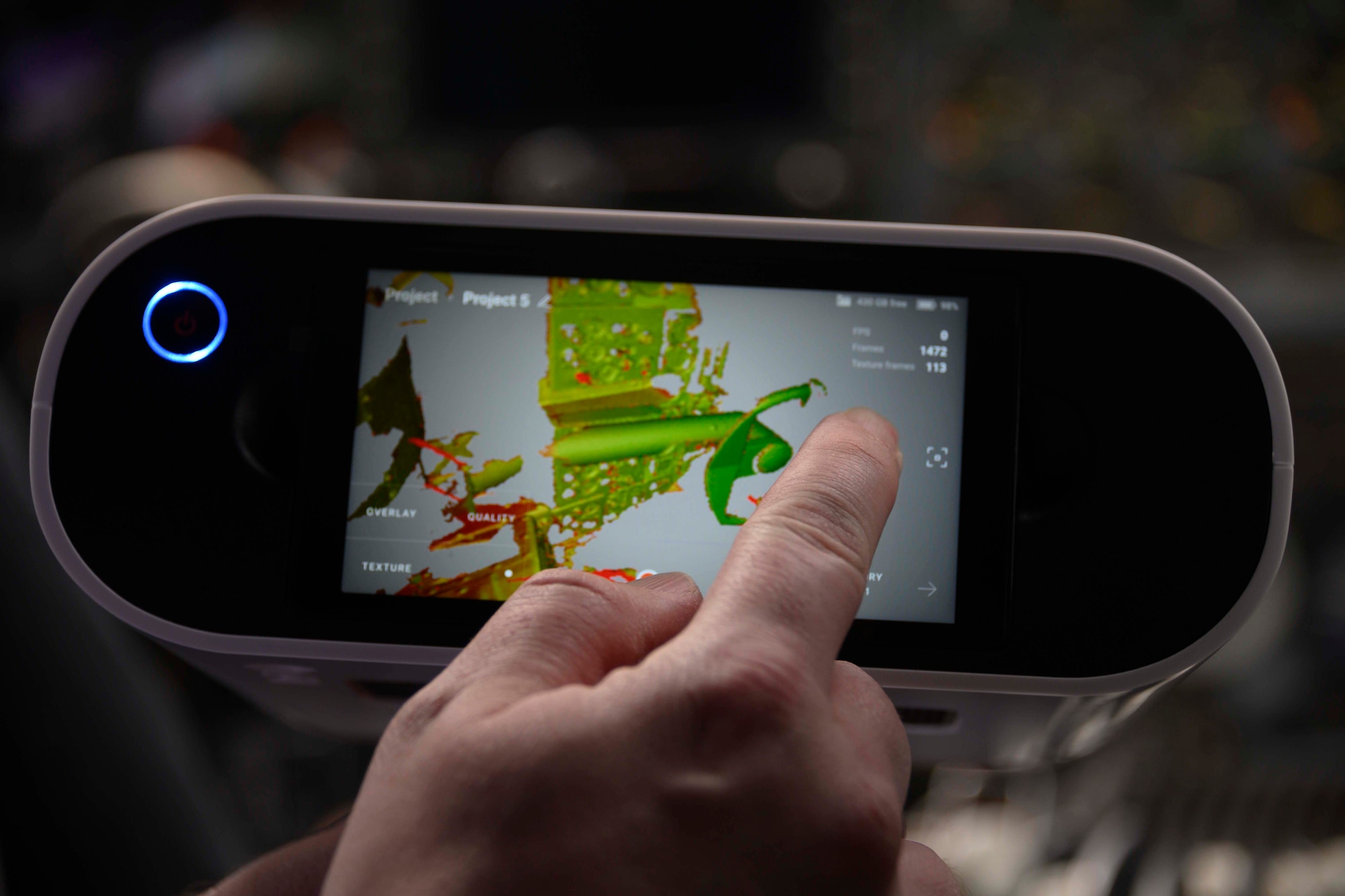 Photo of a man pointing at screen of a 3D scanner.