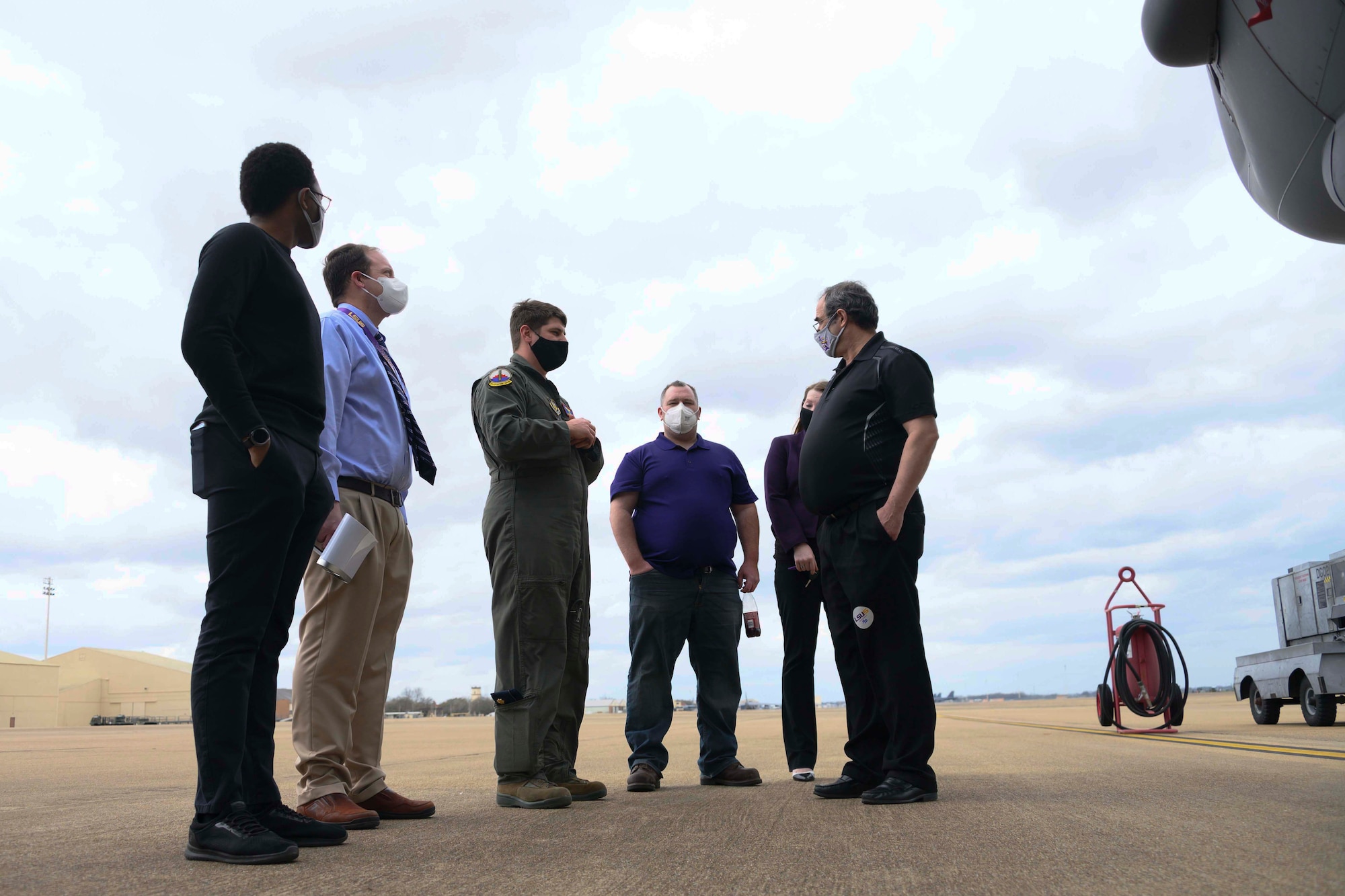 A group of people converse on the flight line at Barksdale Air Force Base.