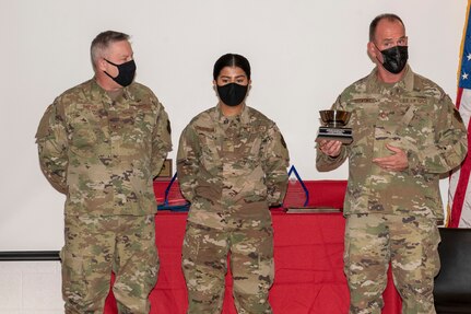 U.S. Air Force Brig. Gen. Ray Shepard, the Assistant Adjutant General- Air for West Virginia, left, and Command Chief Master Sgt. David Stevens, West Virginia Air National Guard Command Chief, right, present Airman 1st Class Pujaba Chudasama, with the James Kemp McClaughlin trophy during the 167th Airlift Wing’s Outstanding Airman of the Year ceremony March 7, 2021.