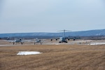 Two A-10 Thunderbolt II aircraft from the 104th Fighter Squadron of the 175th Wing, Maryland Air National Guard, and a C-17 Globemaster III with the 167th Airlift Squadron, 167th Airlift IWng, West Virginia Air National Guard, taxi to the runway at Shepherd Field, Martinsburg, West Virginia, Feb. 17, 2021, as part of an exercise to demonstrate Agile Combat Employment (ACE) capabilities.