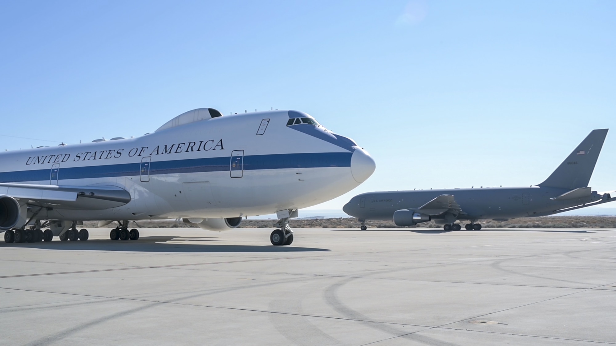 A KC-46 taxis past an E-4B assigned to Eighth Air Force and based out of Offutt Air Force Base, Nebraska, on Edwards Air Force Base, California, Feb. 24. The KC-46 conducted mid-air refueling flight tests with the E-4B in February. (Air Force photo by Giancarlo Casem)