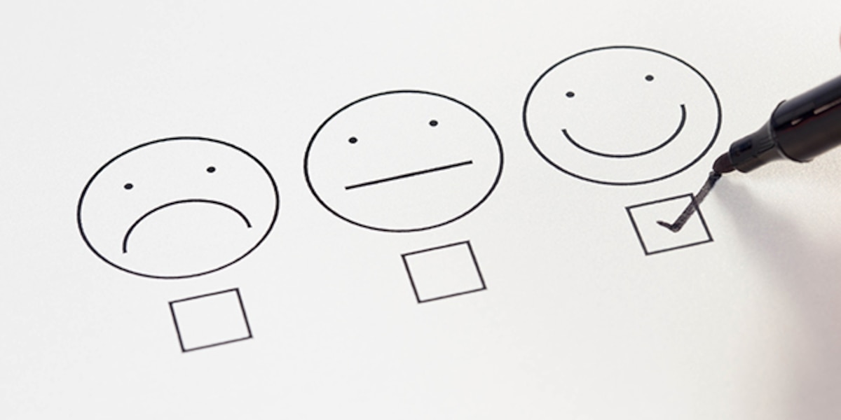 Drawing of 3 faces: an unhappy face, a neutral face and a happy face with filled check box under the happy face.