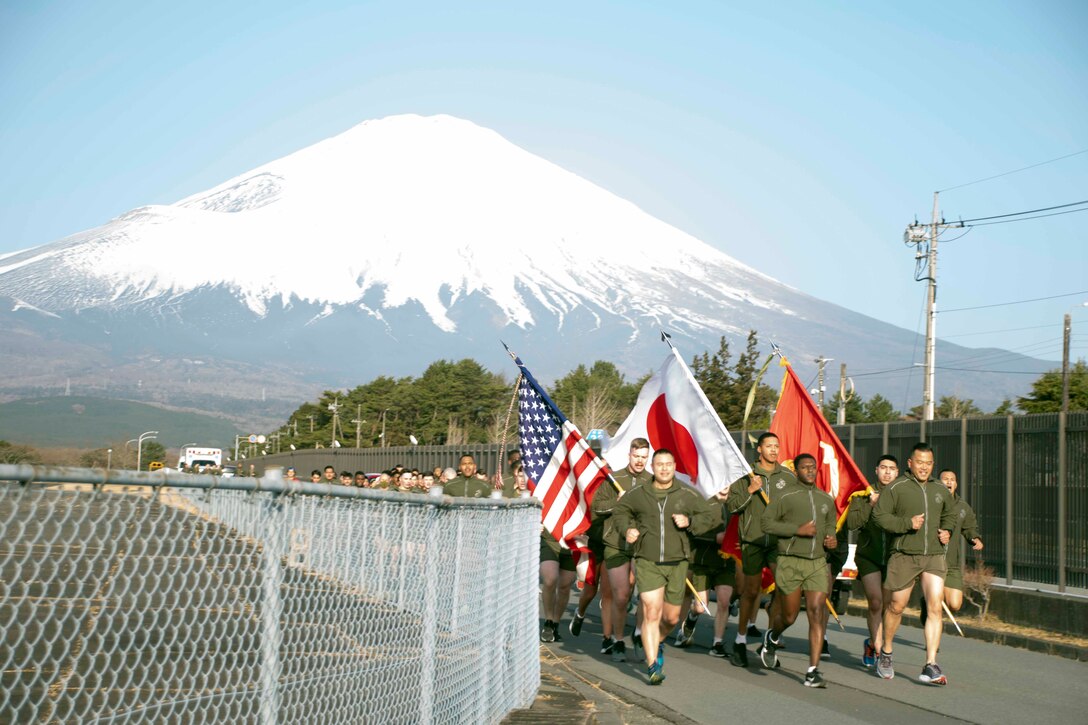キャンプ富士の隊員や従業員など１２０名余りが３月１１日、日米両国旗を掲げ列を組んで東日本大震災追悼のランを行いました。