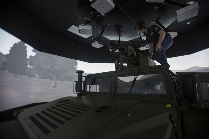 A Simulator Integration Center and Range Control Operations Complex employee helps set up a convoy simulator for Israeli Defense Forces leaders during a tour from II Marine Expeditionary Force personnel which showcased various simulation and training facilities on Camp Lejeune, N.C., Mar. 10, 2021.