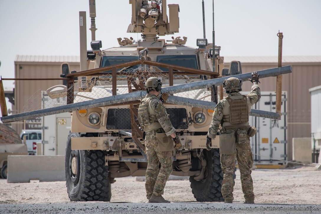 airmen look at heavy machine
