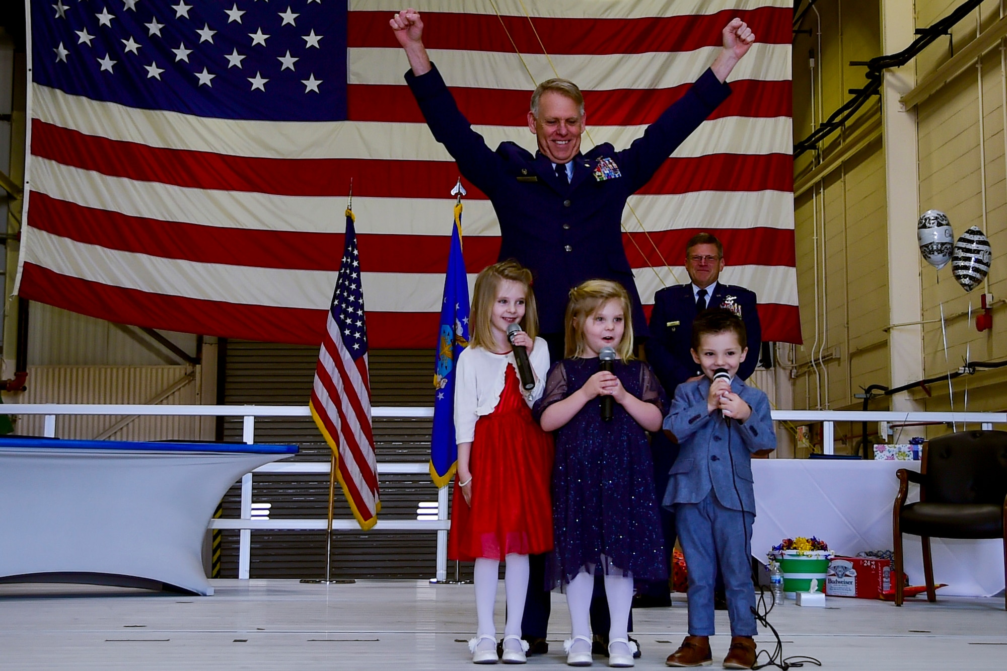 Col. Larry Shaw and his grandchildren sing the Air Force song during his retirement ceremony held at Grissom Air Reserve Base, Ind., March 13, 2021. Shaw retired as the commander of the 434th Air Refueling Wing after serving 33 years in the Air Force as a navigator and pilot. (U.S. Air Force photo by Staff Sgt. Chris Massey)