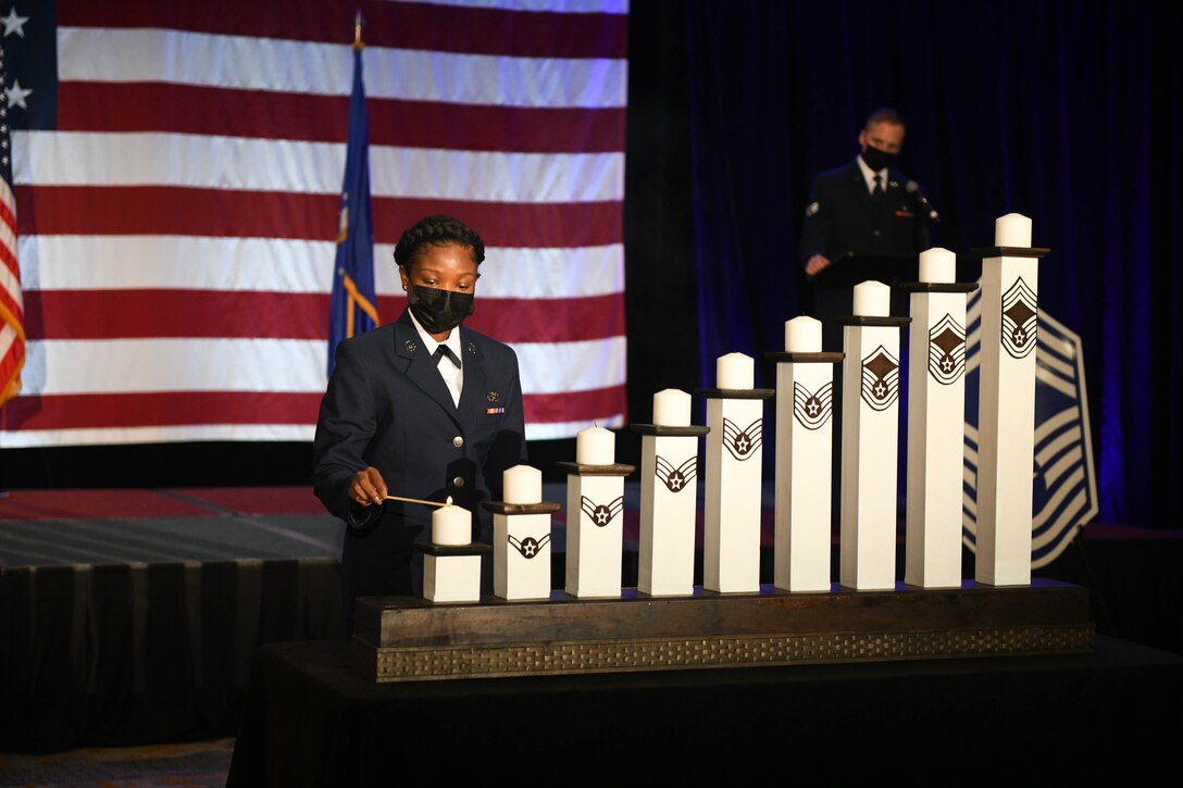 An Airman lights the first of nine candles.
