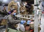 433rd Aeromedical Evacuation Squadron personnel respond to a simulated patient emergency during a KC-46A Pegasus local flight from Joint Base San Antonio-Lackland, Texas, March 10, 2021. The Airmen were conducting initial qualification training on the new aircraft. (U.S. Air Force photo by Tech. Sgt. Iram Carmona)