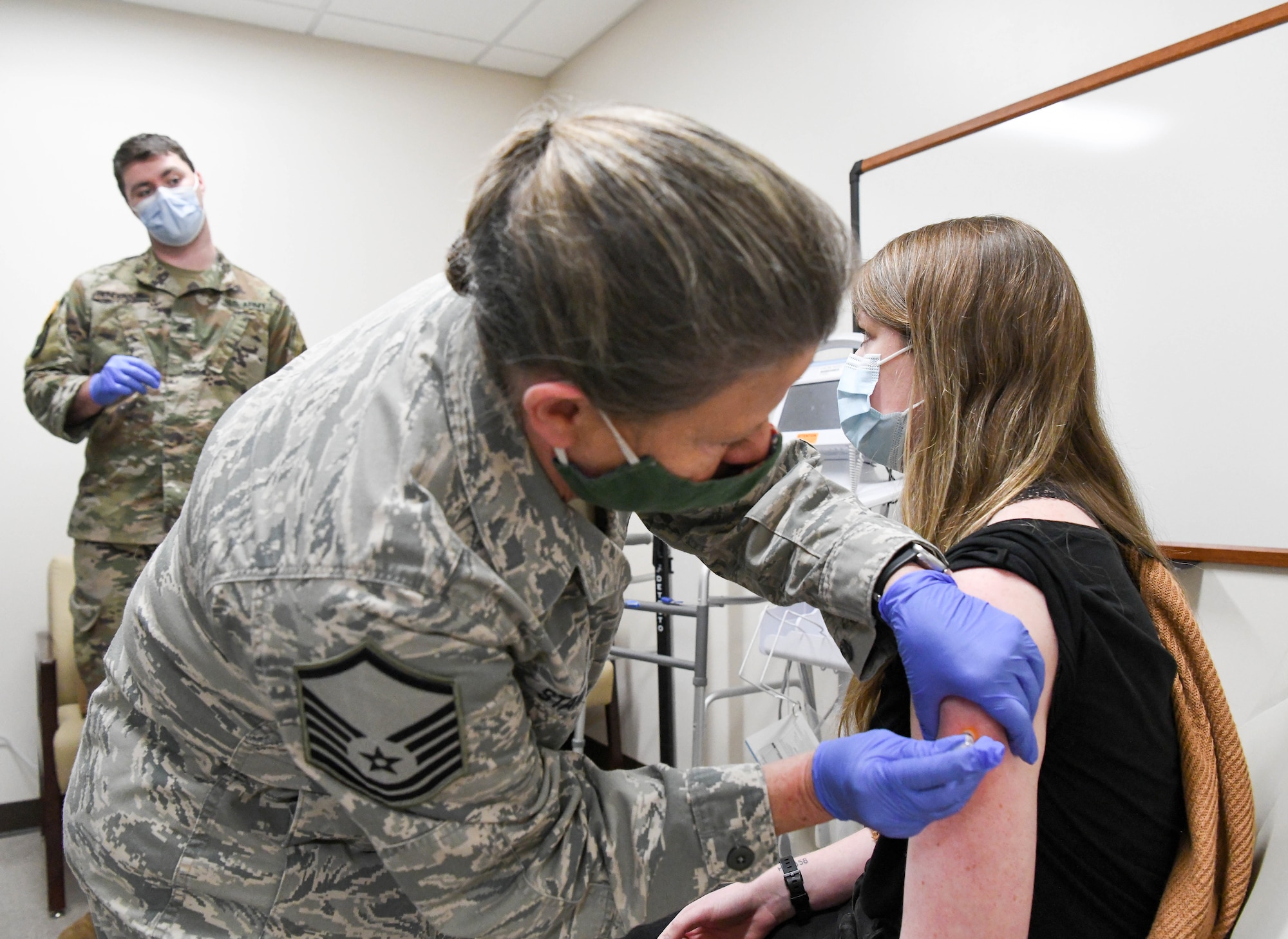 Master Sgt. Marti Stanley with the Tennessee Air National Guard gives a COVID-19 vaccine to Lauren Arnold, an Arnold Engineering Development Complex team member, at Arnold Air Force Base, Tenn., Feb. 23, 2021, at the Medical Aid Station on base. Stanley and Sgt. Dillon Henderson, a member of the Tennessee Army National Guard, administered the vaccines as part of their duties on the COVID Joint Task Force. (U.S. Air Force photo by Jill Pickett)