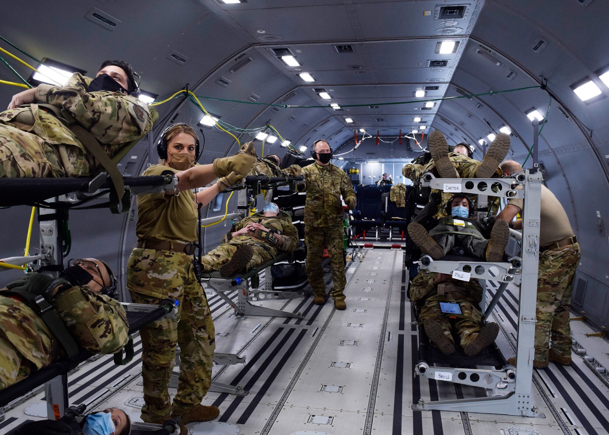 433rd Aeromedical Evacuation Squadron medics receive simulated patients onboard a KC-46A Pegasus during initial qualification training March 9, 2021, at Joint Base San Antonio-Lackland, Texas. During the training flights, the personnel simulated providing patient care to include responding to medical emergencies. (U.S. Air Force photo by Senior Airman Brittany Wich)