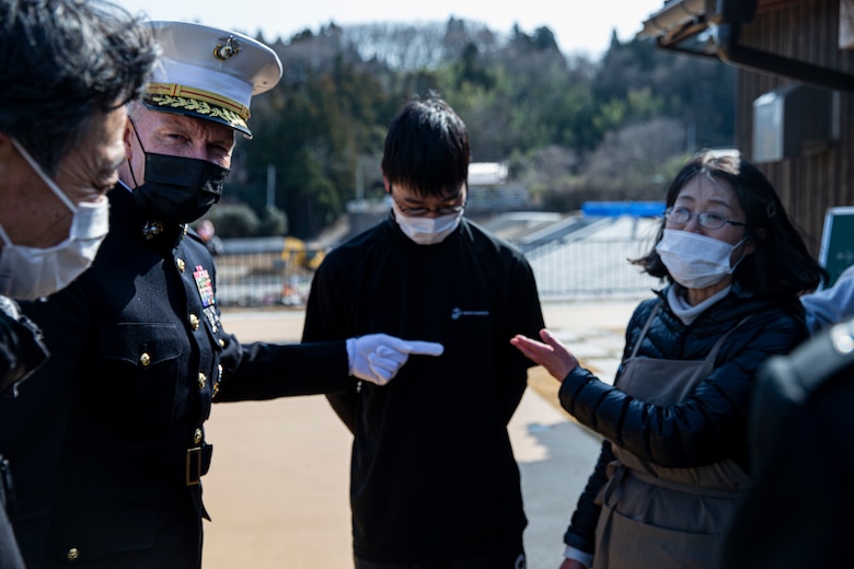 U.S. Marine Corps Brig. Gen. William Bowers, Marine Corps Installations Pacific commanding general, interacts with Wataru Kikuta, 18 (center), and his father Takeshi and mother Reiko, on Oshima Island, Kesennuma, Japan, March 11, 2021. The Kikuta family’s home and fish shop was completely destroyed by the tsunami, and Marines came to their aid following the disaster, helping them to restart their lives. The family has remained in touch with Marines who helped them 10 years ago. The U.S. response, Operation Tomodachi, would become the largest Japan-U.S. bilateral operation, involving nearly 25,000 U.S. service members that assisted with aid efforts across the affected areas of Japan. (U.S. Marine Corps photo by Lance Cpl. Alex Fairchild)