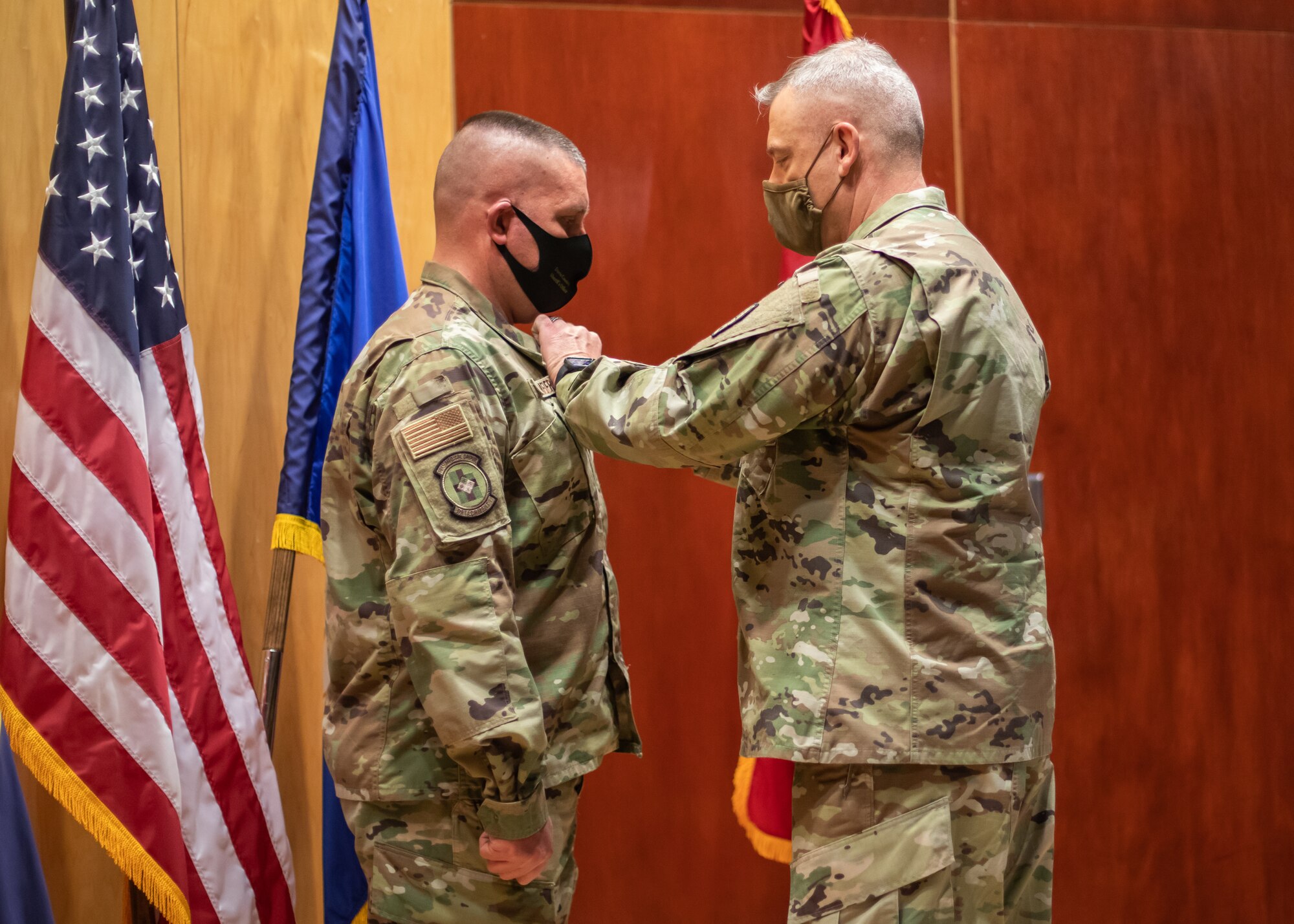 Utah Air National Guard Tech. Sgt. Erik Bornemeier, a medical technician assigned to the 151st Medical Group, Detachment 1, receives the Utah Cross from Maj. Gen. Michael J. Turley, adjutant general, March 15, 2021, at Roland R. Wright Air National Guard Base. The Utah Cross is the second-highest state award a Utah National Guard military member can receive.