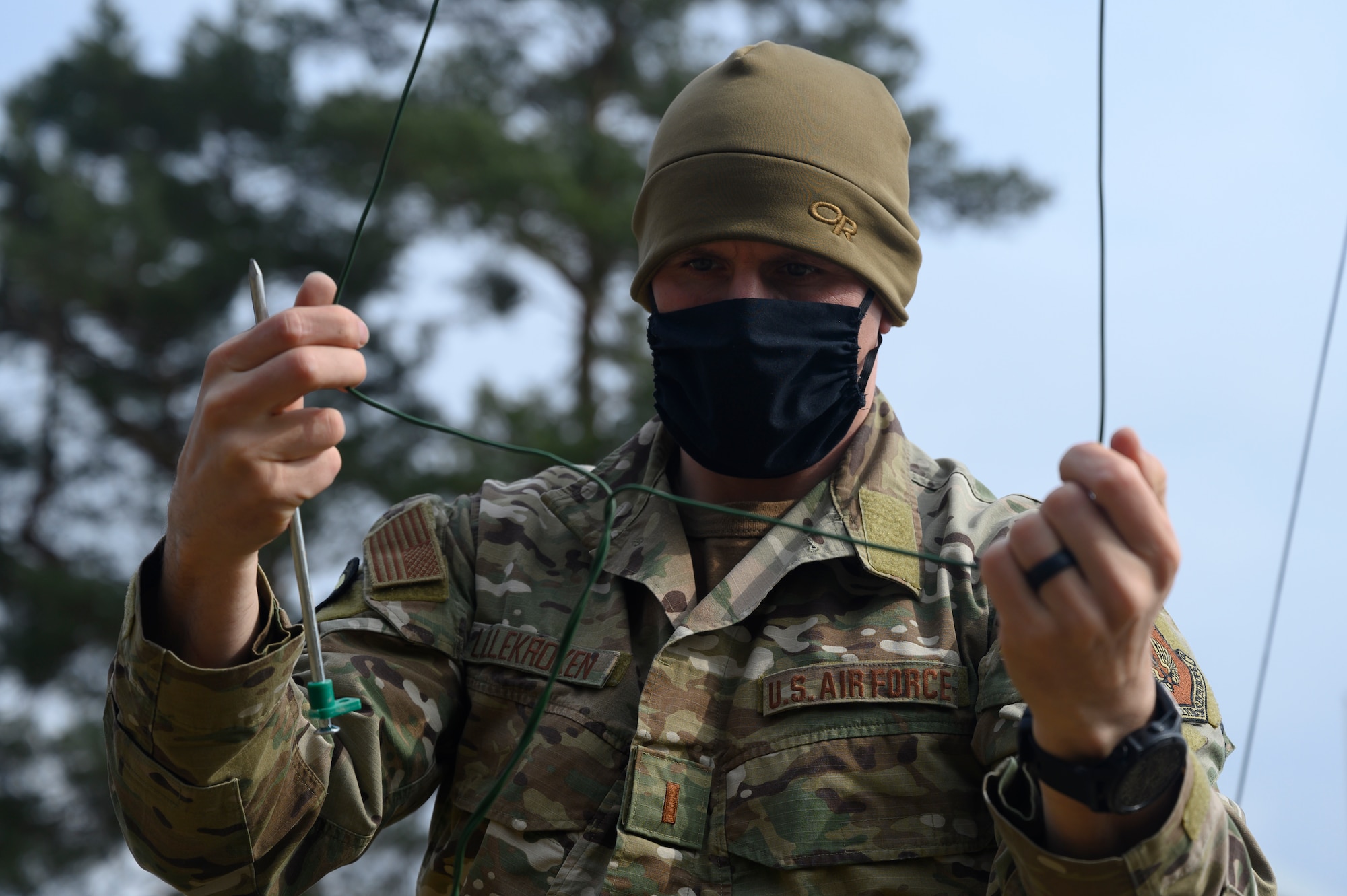 An Airman untangles a wire.