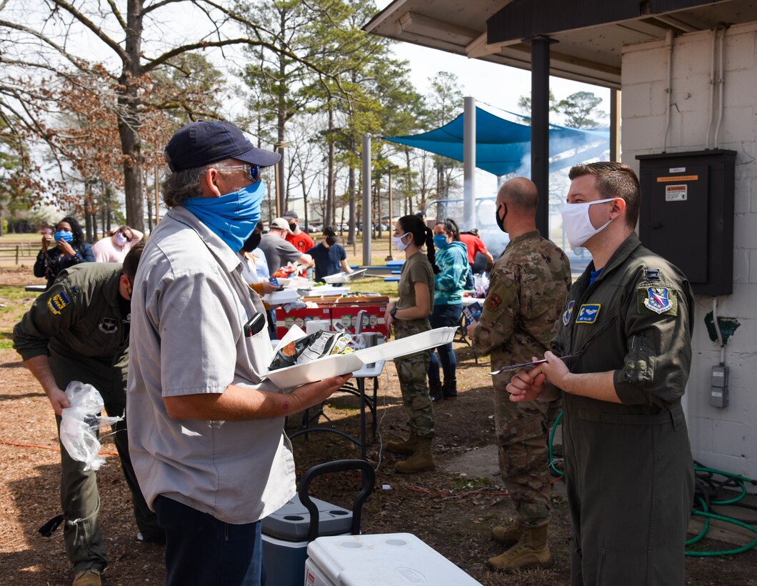 Two 14th Flying Training Wing members discuss the Air Force Assistance Fund on March 12, 2021, at Columbus Air Force Base, Miss. Columbus AFB hosted a “Burger Burn” to kick-off the 2021 season of the AFAF. (U.S. Air Force photo by Sharon Ybarra)