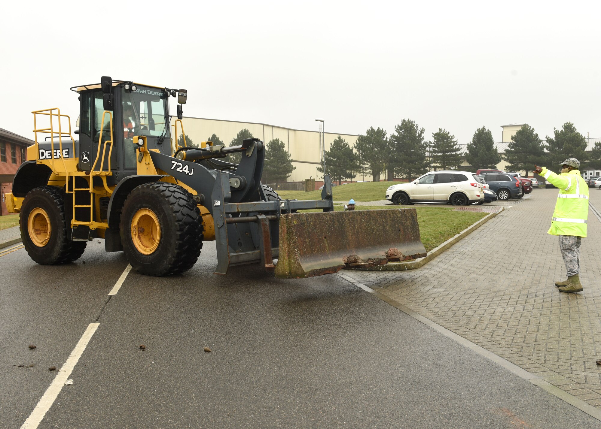 U.S. Air Force Senior Airman Tyler Miller, left, 100th Civil Engineer Squadron, drives a loader to move concrete Jersey barriers as part of protection around a facility as Tech. Sgt. Michael Gilmore, 100th CES, helps guide him to position them into place at Royal Air Force Mildenhall, England, March 16, 2021. The exercise was made up of a variety of scenarios to test the base’s emergency response and base defense for potential threats. (U.S. Air Force photo by Karen Abeyasekere)