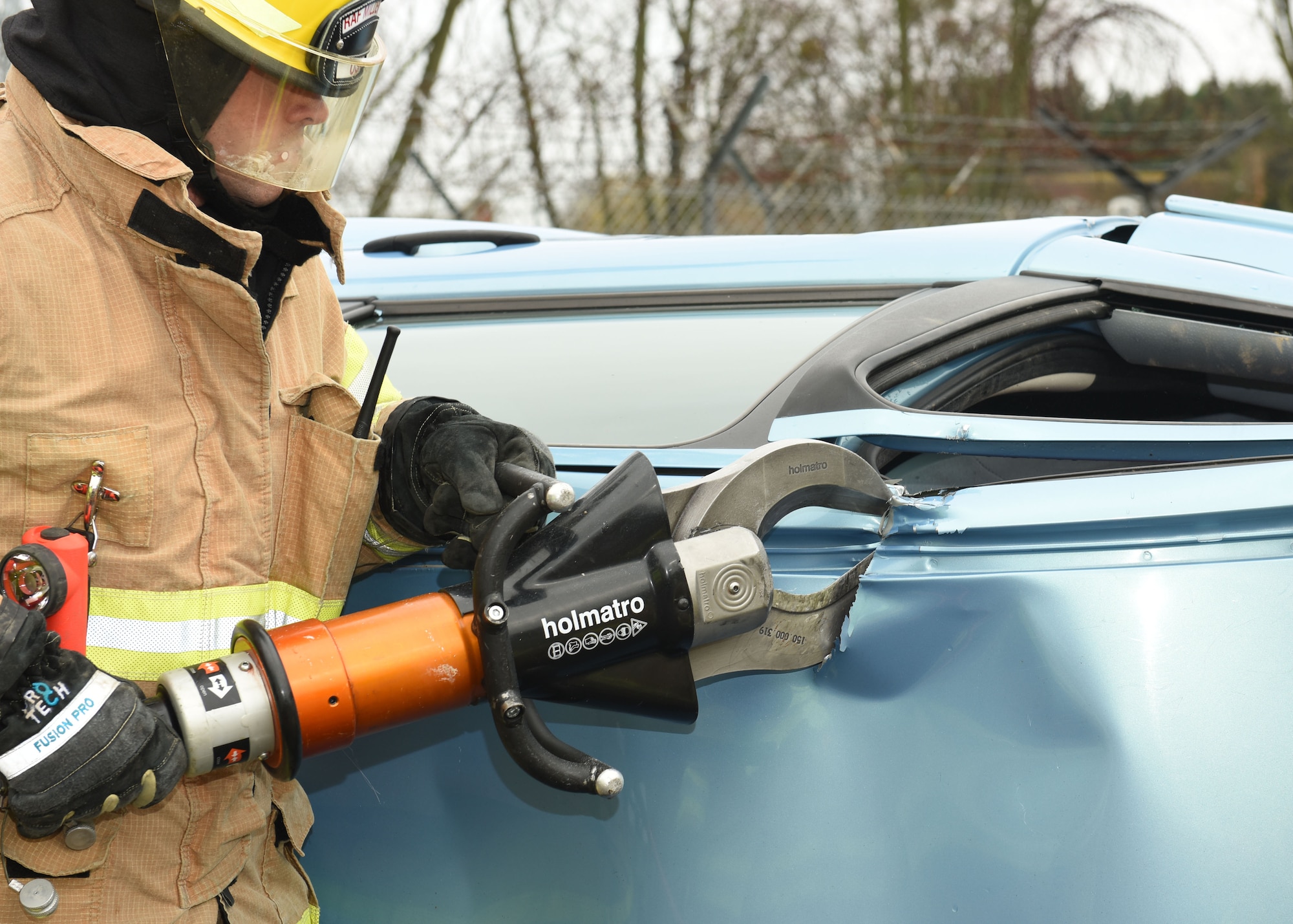 U.S. Air Force Airman 1st Class Benjamin Bergeron, 100th Civil Engineer Squadron Fire Department firefighter, uses the Jaws of Life to cut the roof off a car during a simulated car crash and gate runner scenario as part of an exercise at Royal Air Force Mildenhall, England, March 16, 2021. The exercise was made up of a variety of scenarios to test the base’s emergency response and base defense for potential threats. (U.S. Air Force photo by Karen Abeyasekere)
