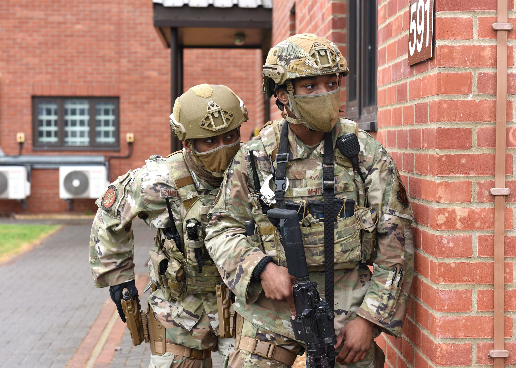U.S. Air Force Tech. Sgt. Fabian Zimmerman, left, 100th Security Forces Squadron operations flight sergeant, and Senior Airman Kevin White, 100th SFS Base Defense Operations Center controller, keep watch for a suspect during a simulated gate runner incident as part of an exercise at Royal Air Force Mildenhall, England, March 16, 2021. The exercise was made up of a variety of scenarios to test the base’s emergency response and base defense for potential threats. (U.S. Air Force photo by Karen Abeyasekere)