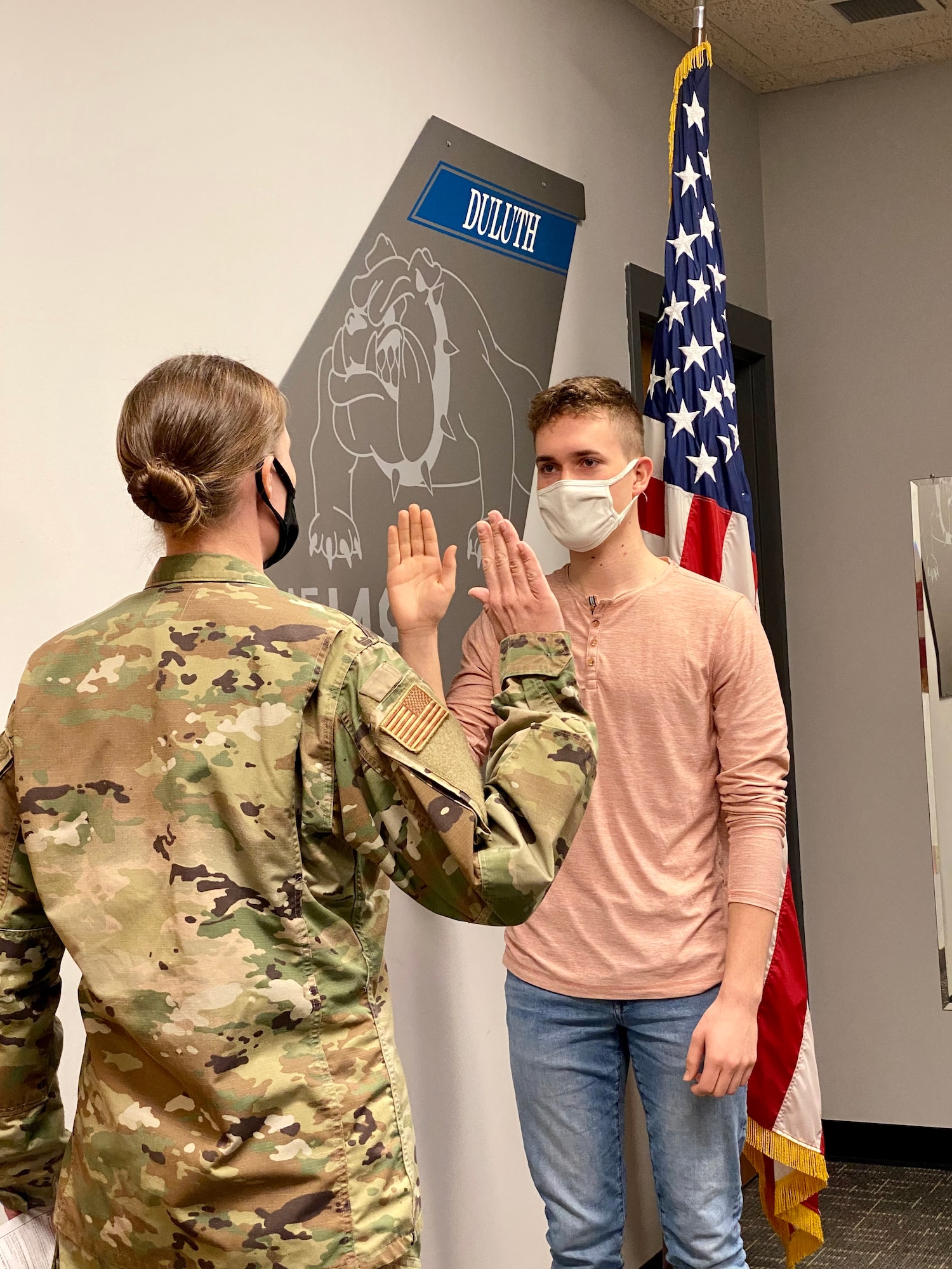 Capt. Mylii Pukema administers the Oath of Office to her nephew, Joey Gigliotti on March 15, 2021. Gigliotti is the third generation of his family to serve at the 148th Fighter Wing, Minnesota Air National Guard. (U.S. Air National Guard photo by Audra Flanagan)