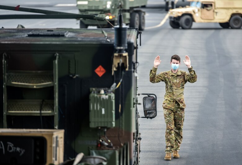 Airman 1st Class Andrew Girard, 535th Airlift Squadron loadmaster, marshals a Soldier with Alpha Battery, 5th Battalion, 3rd Field Artillery Regiment, 17th Field Artillery Brigade before a mission during Exercise TROPIC FURY at Joint Base Pearl Harbour-HIckam, March 12, 2021. Exercise TROPIC FURY demonstrated the 15th Wing’s No. 1 priority, ready now, a key to sustaining operations through the COVID-19 pandemic. (U.S. Air Force photo by Tech. Sgt. Anthony Nelson Jr. )