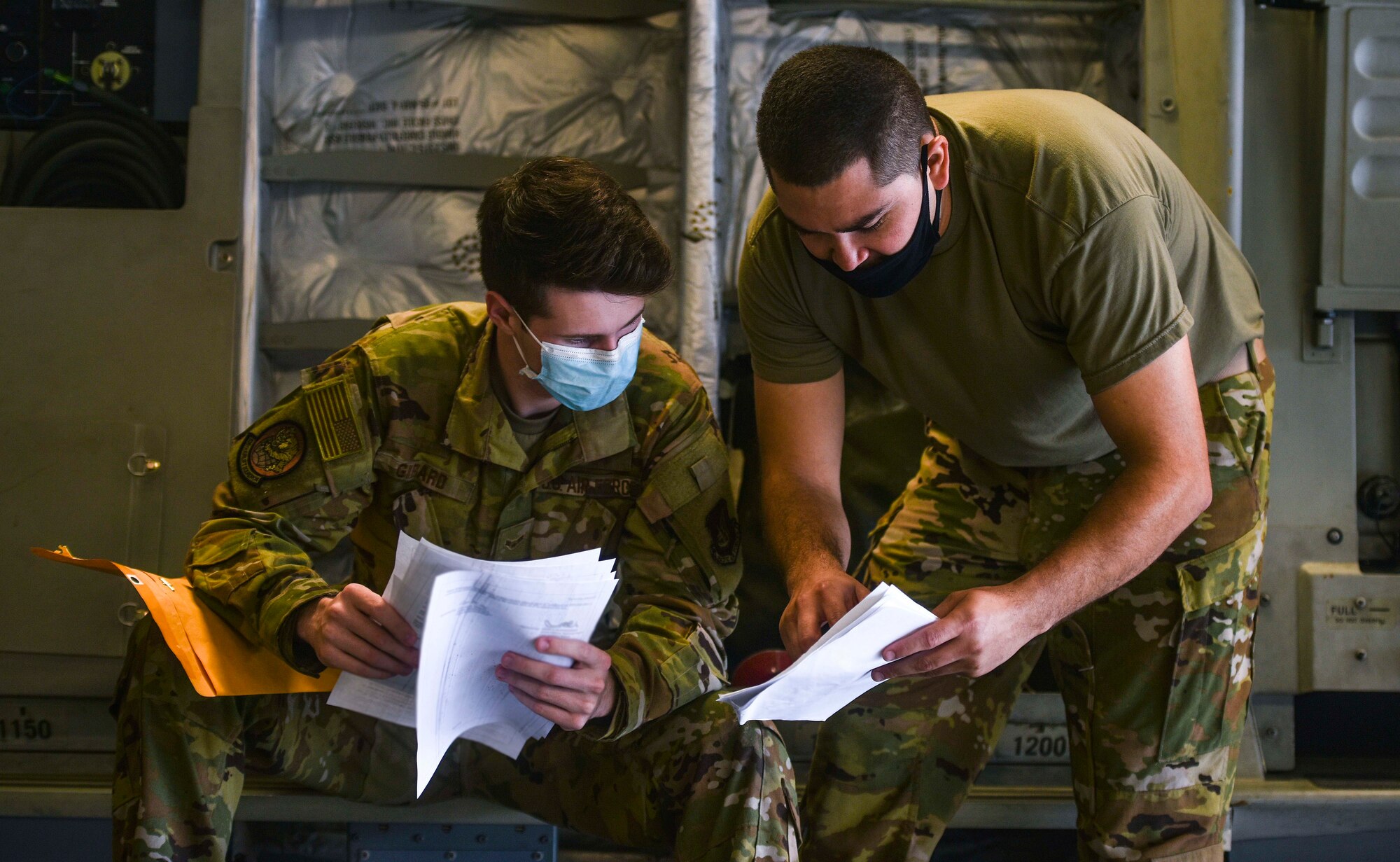 Airman 1st Class Andrew Girard and Tech. Sgt. Anthony Garcia, 535th Airlift Squadron loadmasters, review loading instructions and checklists before a mission during Exercise TROPIC FURY at Joint Base Pearl Harbour-HIckam, March 12, 2021. Exercise TROPIC FURY demonstrated the 15th Wing’s No. 1 priority, ready now, a key to sustaining operations through the COVID-19 pandemic. (U.S. Air Force photo by Tech. Sgt. Anthony Nelson Jr. )