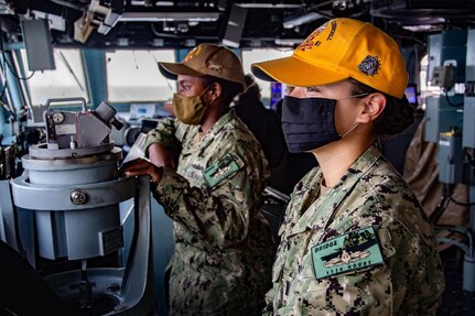210227-N-PS962-1004 (Feb. 27, 2021) – Ens. Leandra Flores-Wenthe, right, Assistant Chief Engineer aboard the guided-missile destroyer USS Winston S. Churchill (DDG 81), and Lt j.g. Blake Smith, Strike Officer aboard Winston S. Churchill, look out into the Red Sea as they stand watch in the pilot house wearing their commemorative patches symbolizing their completion of over 1,110 hours of bridge watchstanding while underway in accordance with the Mariners Skills log book in Red Sea. Winston S. Churchill is deployed to the U.S. 6th Fleet area of operations in support of regional allies and partners and U.S. national security interests in Europe and Africa. (U.S. Navy photo by Mass Communication Specialist 3rd Class Louis Thompson Staats IV)