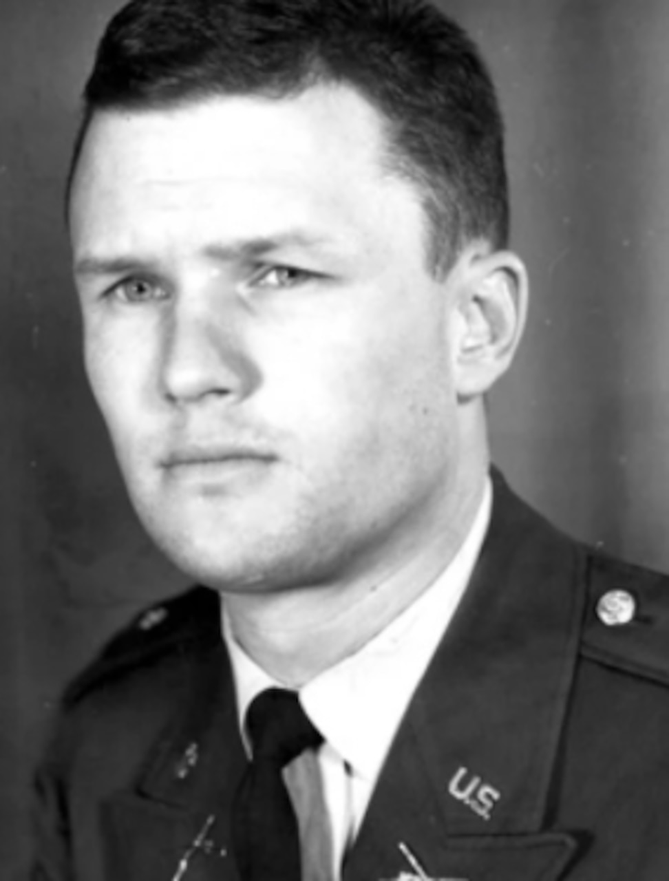 A man in an army uniform poses for photo