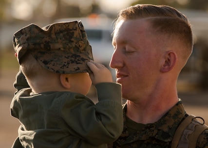 A U.S. Marine with Marine Fighter Attack Squadron (VMFA) 323 greets his family upon his return to MCAS Miramar from a 10-month carrier deployment, Feb. 26, 2021. VMFA-323 completed their last deployment while flying the F/A-18 Hornet and will be transitioning to flying the F-35 Lightning II. (U.S. Marine Corps photo by Lance Cpl. Levi Voss)