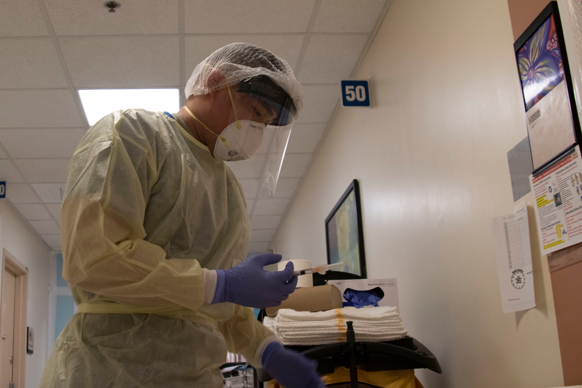 U.S. Air Force 2nd Lt. Chad Lee, 99th Medical Group, Nellis Air Force Base, Nev., dons personal protective equipment during his shift in a telemetry department while providing care to COVID-19 patients at Adventist Health White Memorial Hospital, Los Angeles, Calif., Feb. 2, 2021. U.S. Northern Command, through U.S. Army North, remains committed to providing flexible Department of Defense support to the whole-of-government COVID-19 response. (U.S. Army photo by Pfc. Garrison Waites/5th Mobile Public Affairs Detachment)