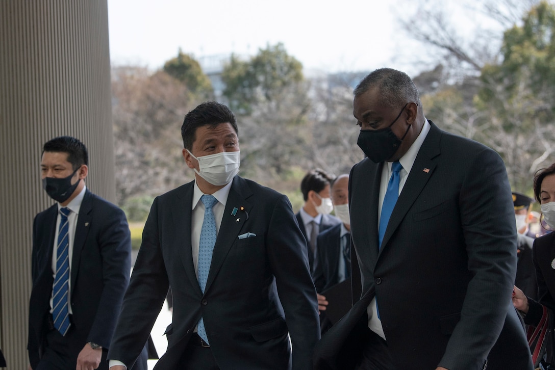 Secretary of Defense Lloyd J. Austin III walks with a civilian official.