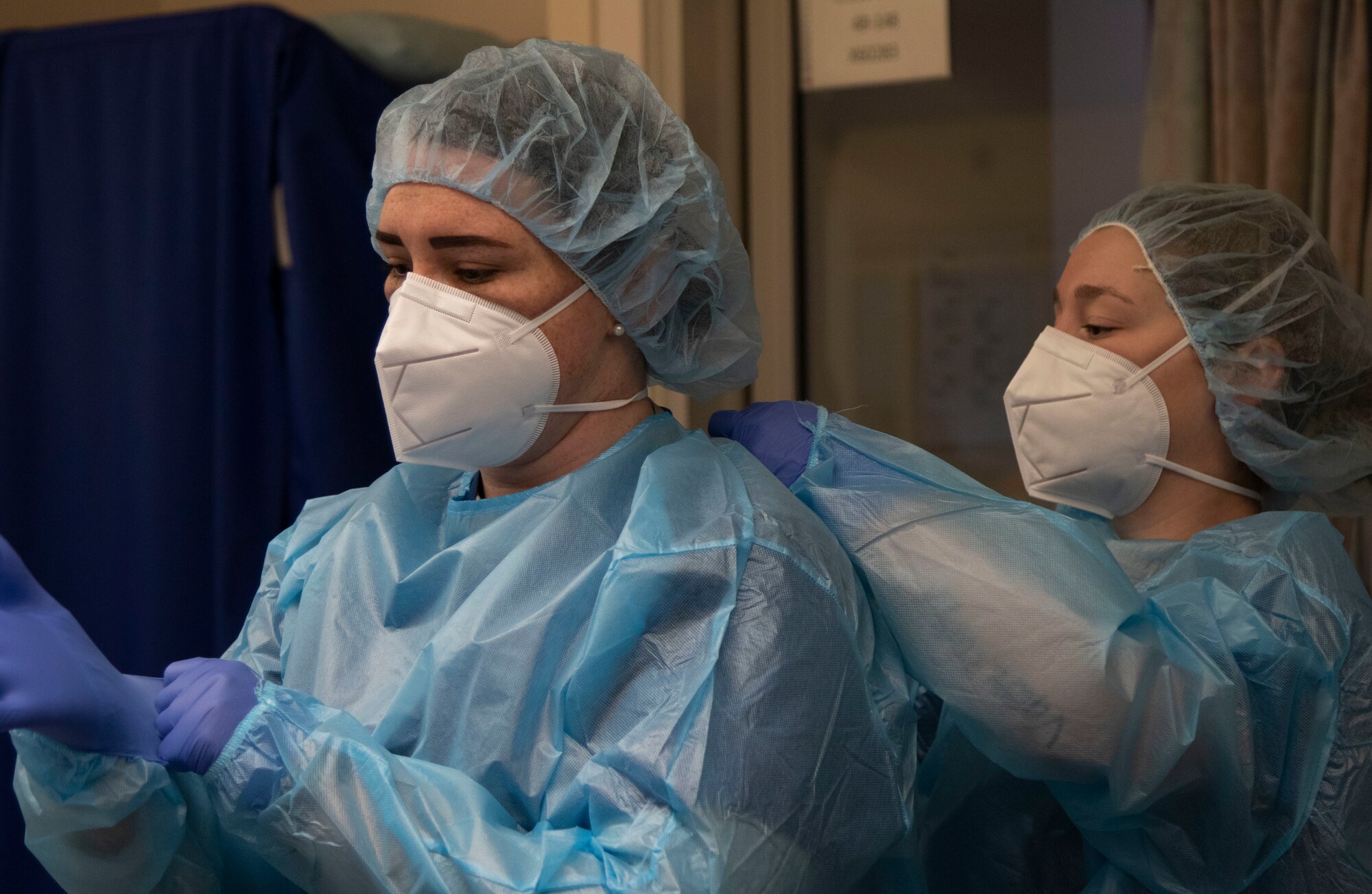 U.S. Air Force Master Sgt. Amanda Orvis, left, and Staff Sgt. Aubrey Woolman with the 99th Medical Group, Nellis Air Force Base, Nev., don personal protective equipment ahead of providing care to COVID-19 positive patients in an intensive care unit at LAC+USC Medical Center in Los Angeles, Calif., Jan. 18, 2021. U.S. Northern Command, through U.S. Army North, remains committed to providing flexible Department of Defense support to the whole-of-America COVID-19 response. (U.S. Army photo by Pfc. Garrison Waites/5th Mobile Public Affairs Detachment)