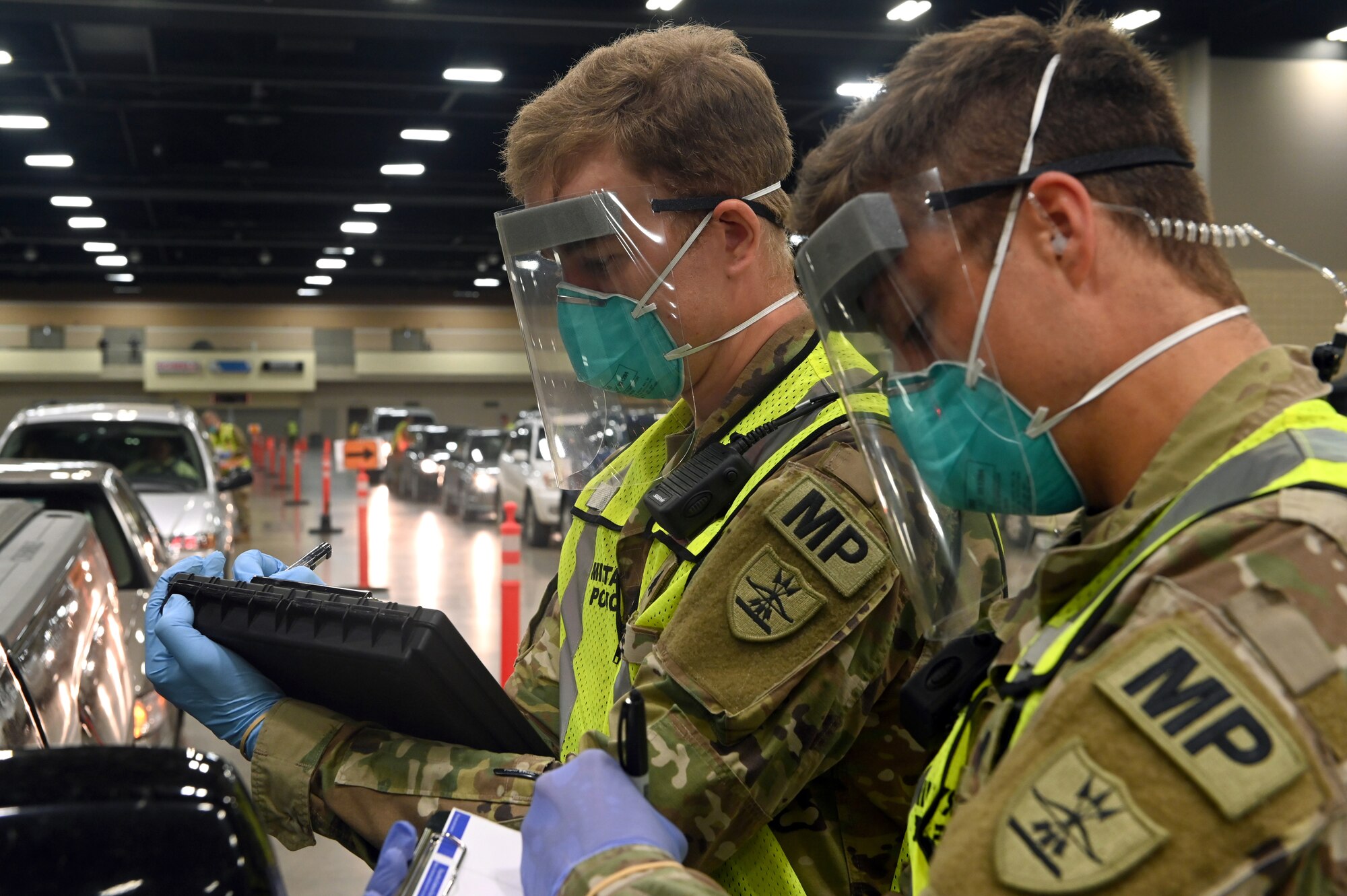 Sgt. Chase Bode, left, and Spc. Isaac Bolton of the 816th Military Police Company, North Dakota National Guard, collect data at the COVID-19 mobile testing site inside the Bismarck Event Center in Bismarck, North Dakota, May 2, 2020. The NDNG marked the one-year anniversary of its support of the pandemic response March 16, 2021.