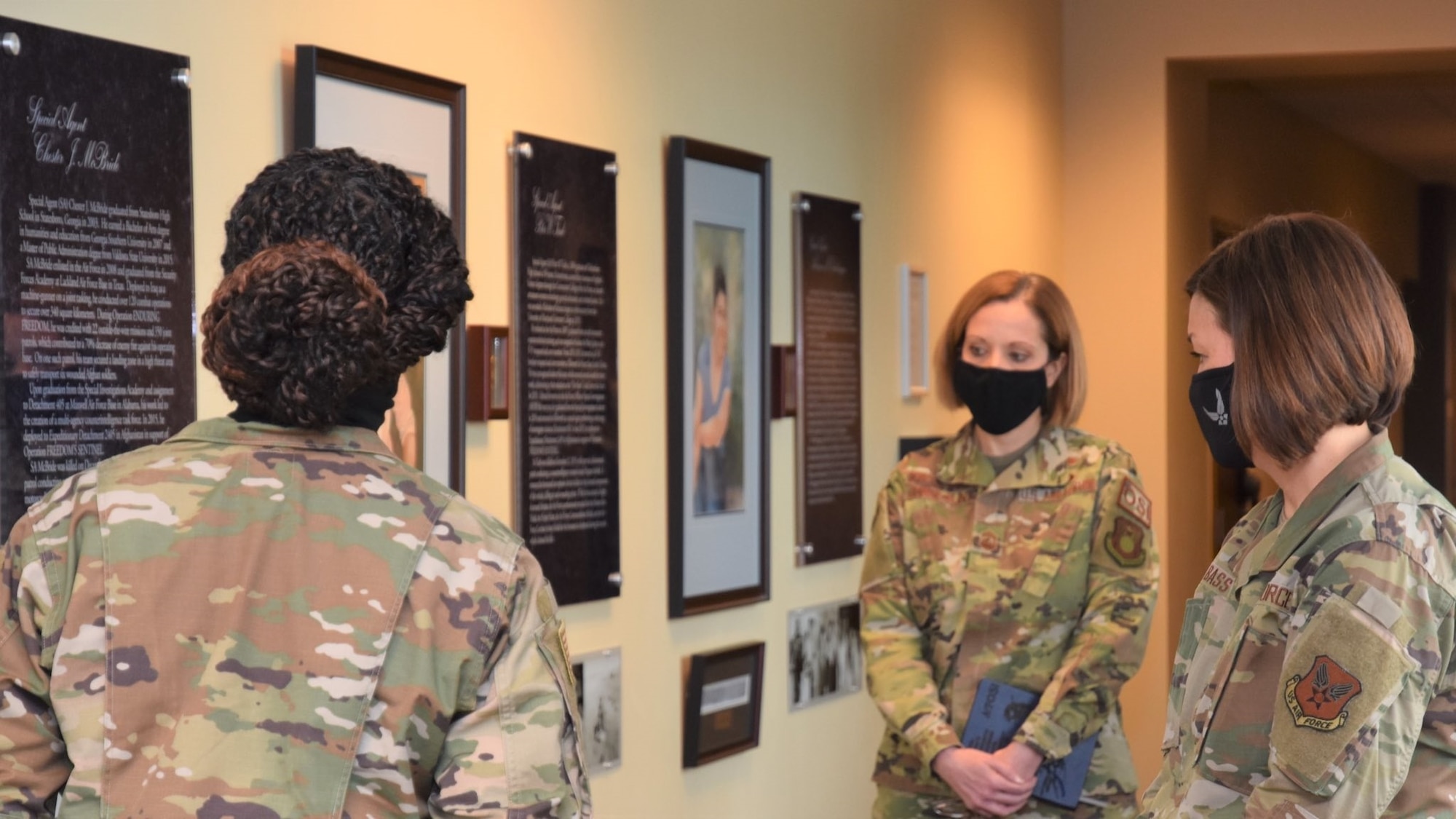 Chief Master Sergeant of the Air Force JoAnne S. Bass, right, tours the Office of Special Investigations Hall of Heroes during her inaugural visit as CMSAF to OSI Headquarters, Quantico, Va., March 12. Guiding the Hall tour is Tech. Sgt. Trakeila Holt, left, and OSI Command Chief Master Sgt. Karen Beirne-Flint. (Photo by SA Spencer King)