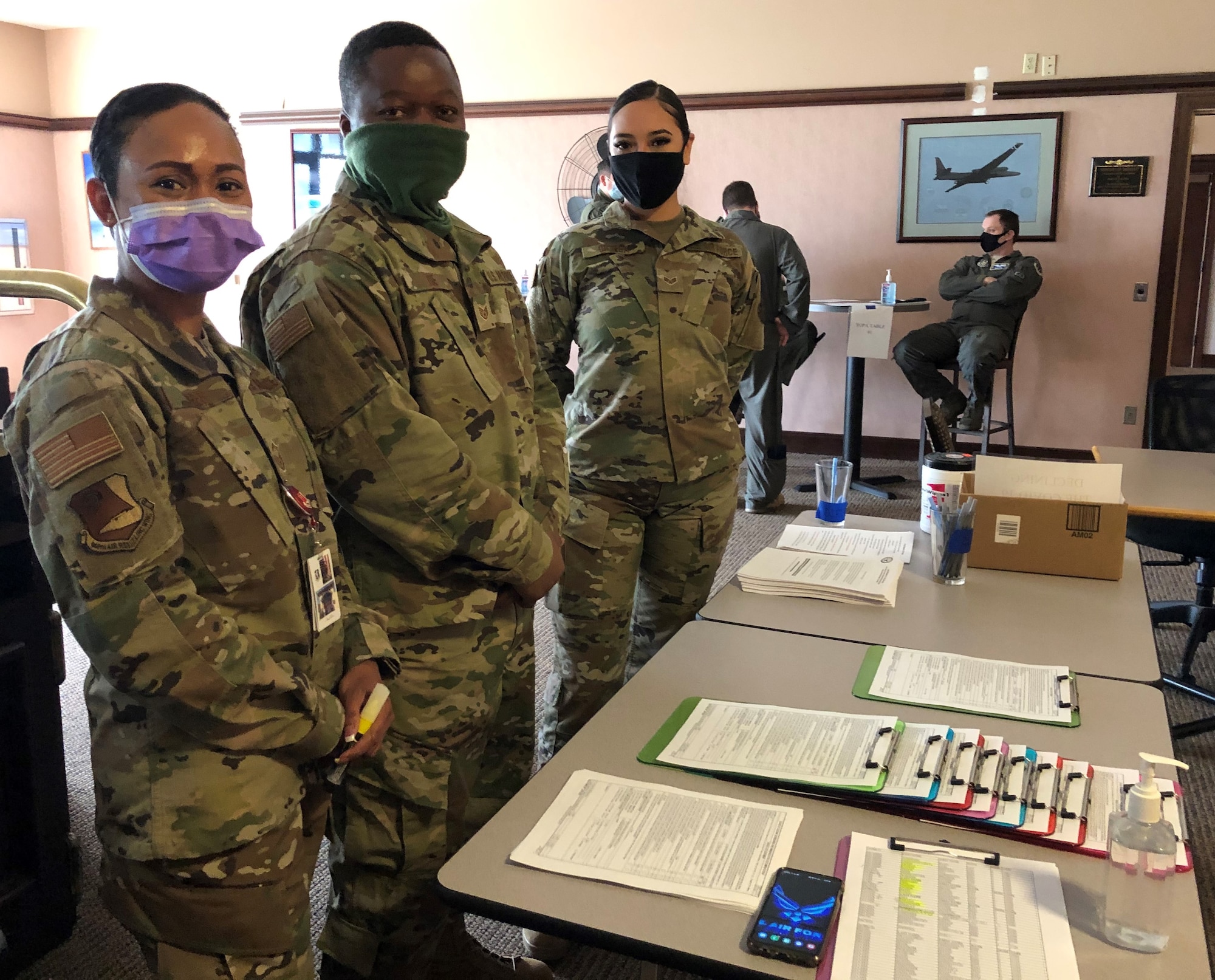 Senior Master Sgt. Ellie Torres, 940th AMDS/SGO, Staff Sgt. Blee Toe, AMDS/AMDS and SrA. Melanie Ortega, AMDS/SGSP  greet the voluntary participants at the Recce Point Club first, before processing through the line for the COVID-19 vaccine.