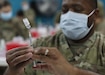 Maj. Gen. Patrick Hamilton, the commanding general of Texas National Guard's 36th Infantry, deployed to Camp Arifjan, Kuwait, as the commanding general of Task Force Spartan braces for his one-dose Janssen Biotech COVID-19 vaccine during the camp's March 13, 2021 rollout of Operation Med Spear. Unlike other COVID-19 vaccines, the Janssen vaccine does not have to be frozen in transit, which makes it easier to distribute to Soldiers deployed overseas. (U.S. Army photo by Staff Sgt. Neil W. McCabe)
