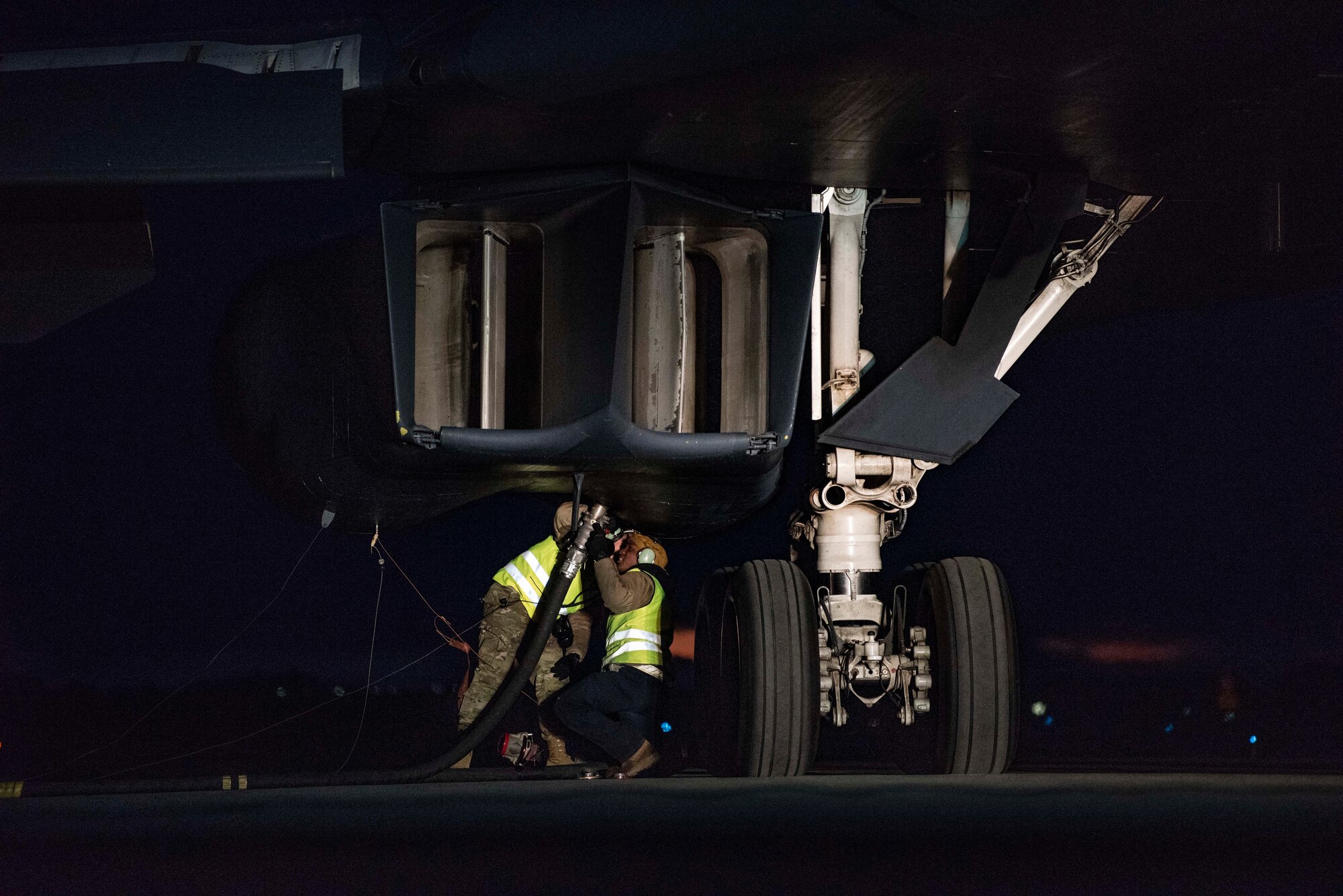 Crew chiefs assigned to the 9th Expeditionary Bomb Squadron attach a fuel hose to a B-1B Lancer as part of a hot-pit refuelling mission at Ørland Air Force Station, Norway, March 12, 2021. During a hot-pit, an aircraft is refuelled shortly after landing without shutting down the engines or auxiliary systems, reducing the amount of time the jet spends on the ground. (U.S. Air Force photo by Airman 1st Class Colin Hollowell)