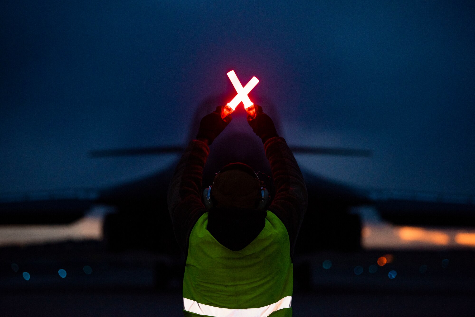 A crew chief assigned to the 9th Expeditionary Bomb Squadron signals to a B-1B Lancer at Ørland Air Force Station, Norway, March 12, 2021. The B-1 underwent the first ever B-1 hot-pit refuel in Europe at Powidz Air Base, Poland during a Bomber Task Force Europe training mission. (U.S. Air Force photo by Airman 1st Class Colin Hollowell)
