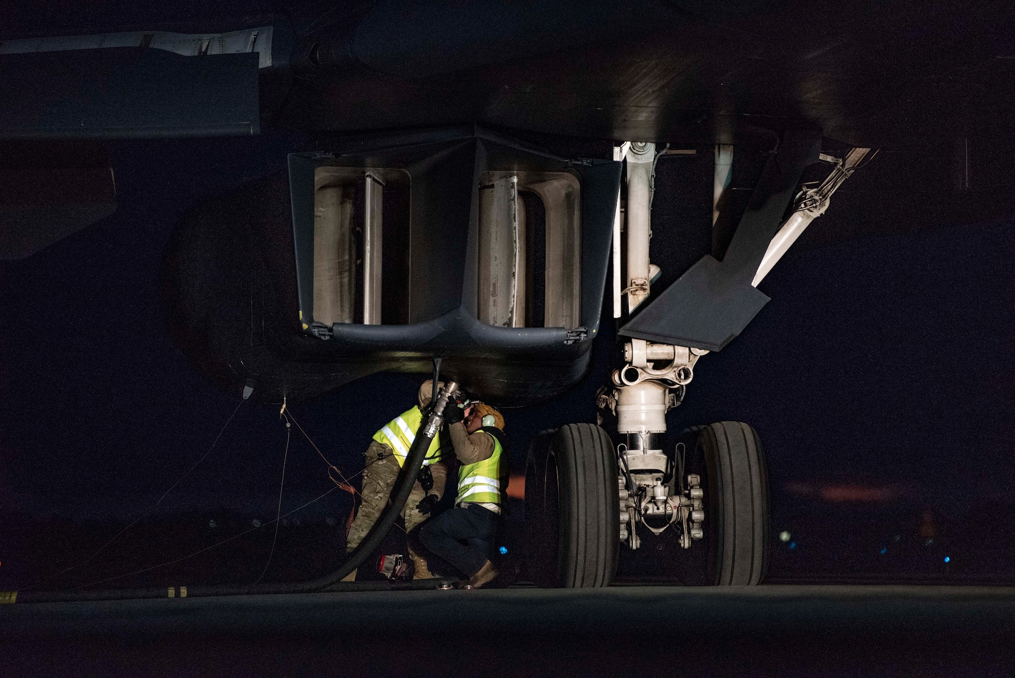 Crew chiefs assigned to the 9th Expeditionary Bomb Squadron attach a fuel hose to a B-1B Lancer as part of a hot-pit refuelling mission at Ørland Air Force Station, Norway, March 12, 2021. During a hot-pit, an aircraft is refuelled shortly after landing without shutting down the engines or auxiliary systems, reducing the amount of time the jet spends on the ground. (U.S. Air Force photo by Airman 1st Class Colin Hollowell)