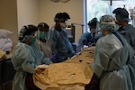 U.S. Air Force Staff Sgt. Minh Tran, third from the left, a medical technician assigned to COVID Theater Hospital-1, and his civilian colleagues prepare to move a patient at Los Angeles County + University of Southern California Medical Center, Los Angeles, Calif., August 10, 2020.  Tran is a member of a medical support team deployed from the 60th Medical Group, Travis Air Force Base, Calif., which integrated with hospital staff to provide additional medical support. U.S. Northern Command, through U.S. Army North, remains committed to providing flexible Department of Defense support to the Federal Emergency Management Agency in support of the whole-of-America COVID-19 response. (U.S. Army photo by Lt. Col. Charles Calio)