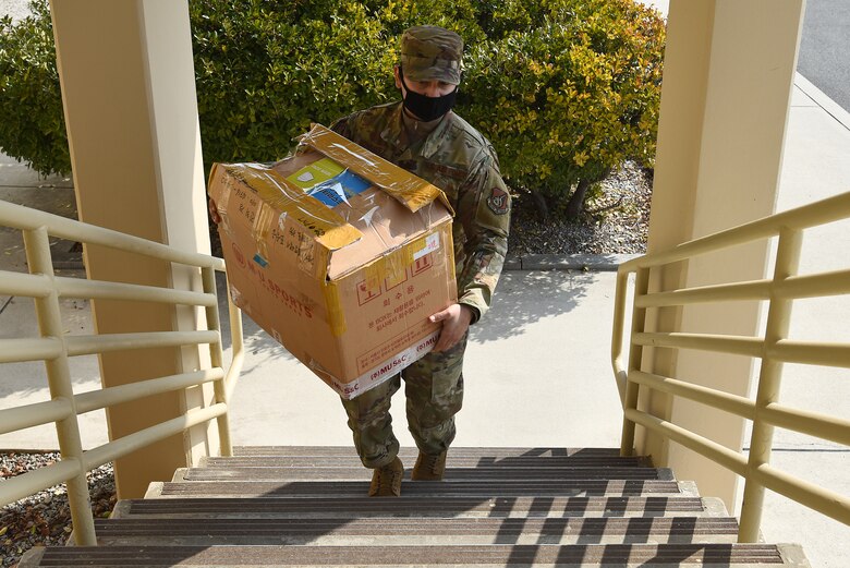 Staff Sgt. William Gonzalez, 8th Fighter Wing administration NCO in-charge, carries a box of donated masks at Kunsan Air Base, Republic of Korea, March 10, 2021. The KAGA donated 3,000 copper reusable masks to the Wolf Pack and has been a community partner for the last 40 years. (U.S. Air Force photo by Senior Airman Suzie Plotnikov)