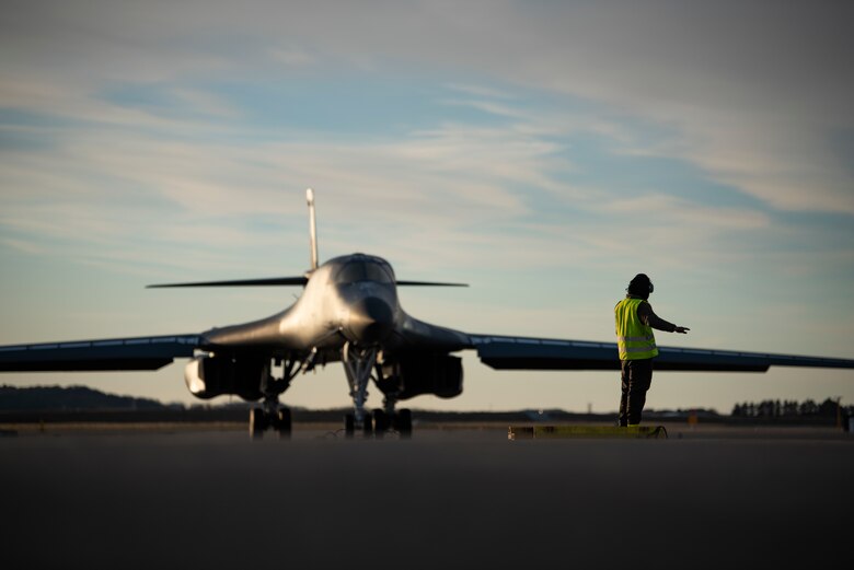 A crew chief assigned to the 9th Expeditionary Bomb Squadron marshals a B-1B Lancer at Ørland Air Force Station, Norway, March 14, 2021. Conducting Bomber Task Force training missions showcases the United States’ strong, credible bomber force while enhancing the security and stability of allies and partners. (U.S. Air Force photo by Airman 1st Class Colin Hollowell)