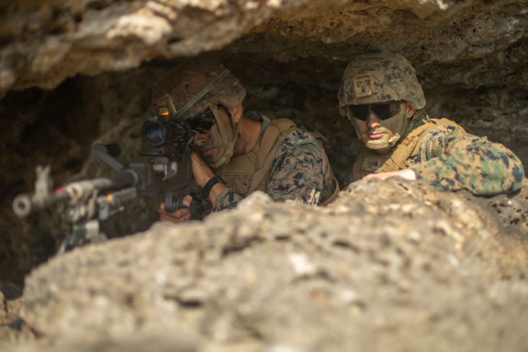 Marine Corps Lance Cpl. Joseph Lopez and Lance Cpl. Zachary Jurkovski, both machine gunners with 3d Battalion, 8th Marine Regiment, 3d Marine Division, examine their sector of fire during Castaway 21.1 at Ie Shima, Okinawa, Japan March 13, 2021.
