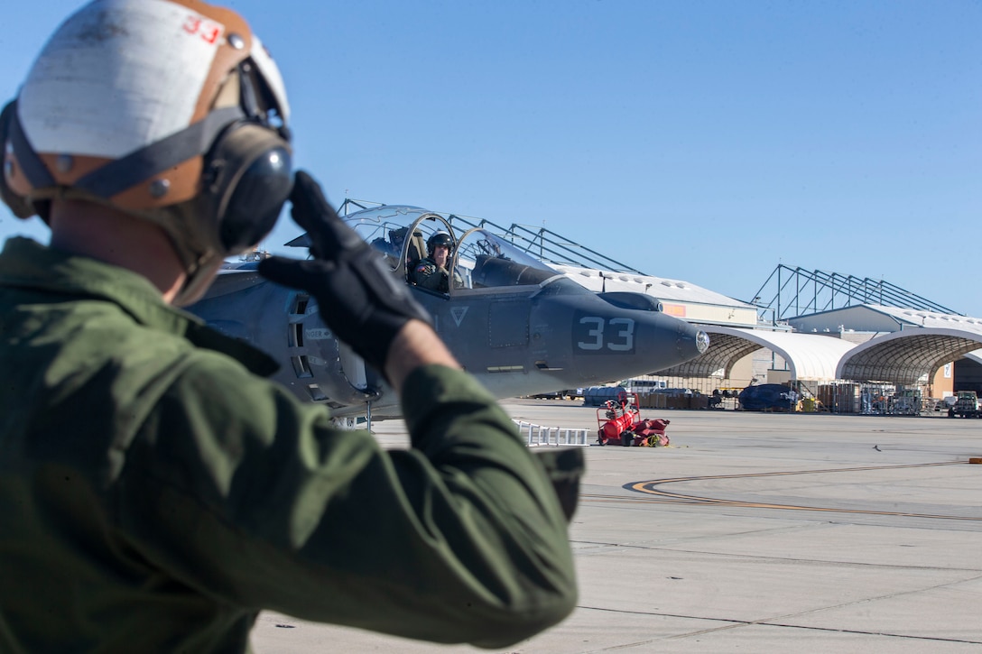Lance Cpl. Carson Batterton, a fixed-wing aircraft mechanic, salutes the pilot of an AV-8B Harrier II as he departs the staging area at Marine Corps Air Station Yuma, Arizona, Feb. 18, 2021.
